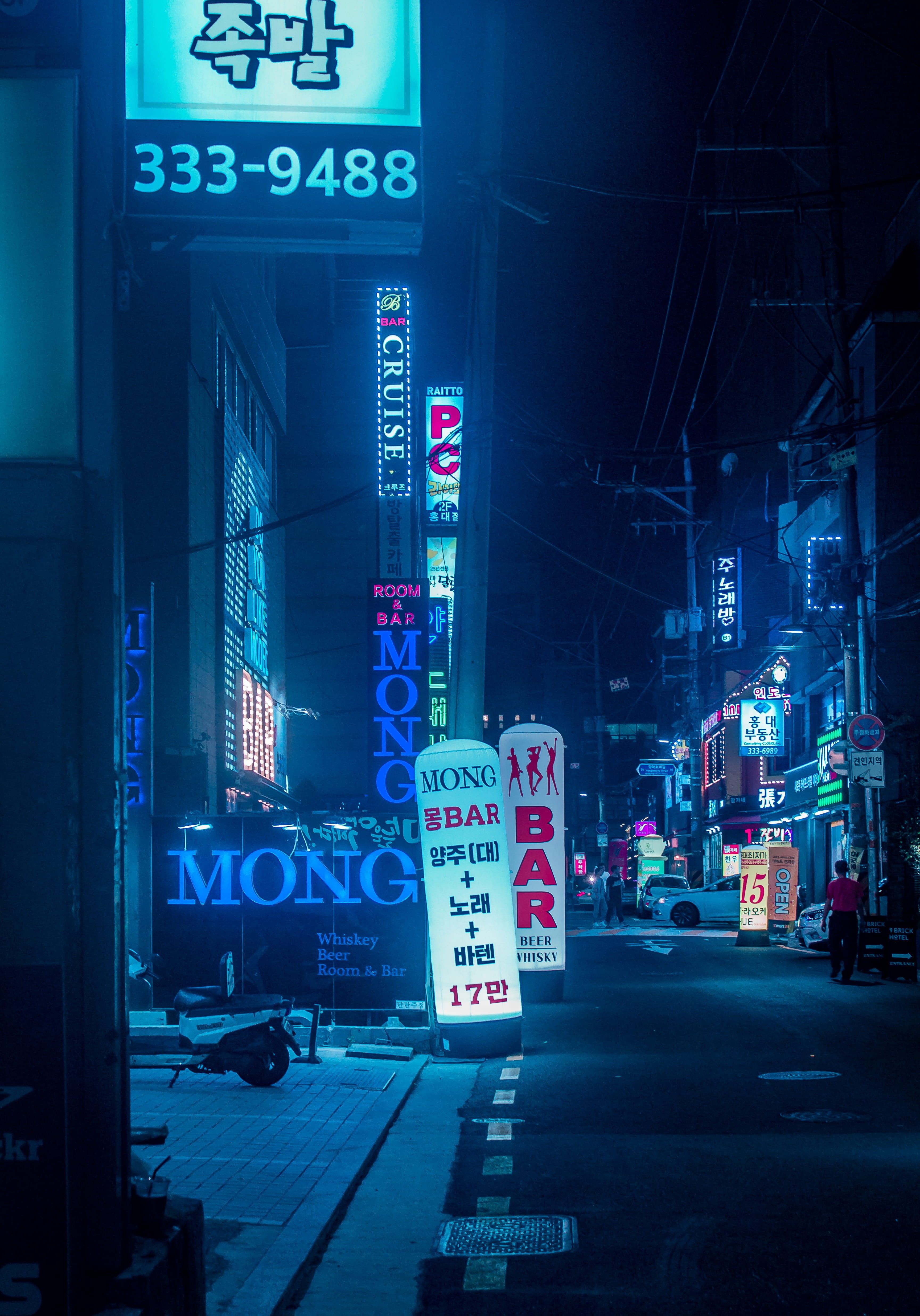 A street at night with neon signs. - Seoul