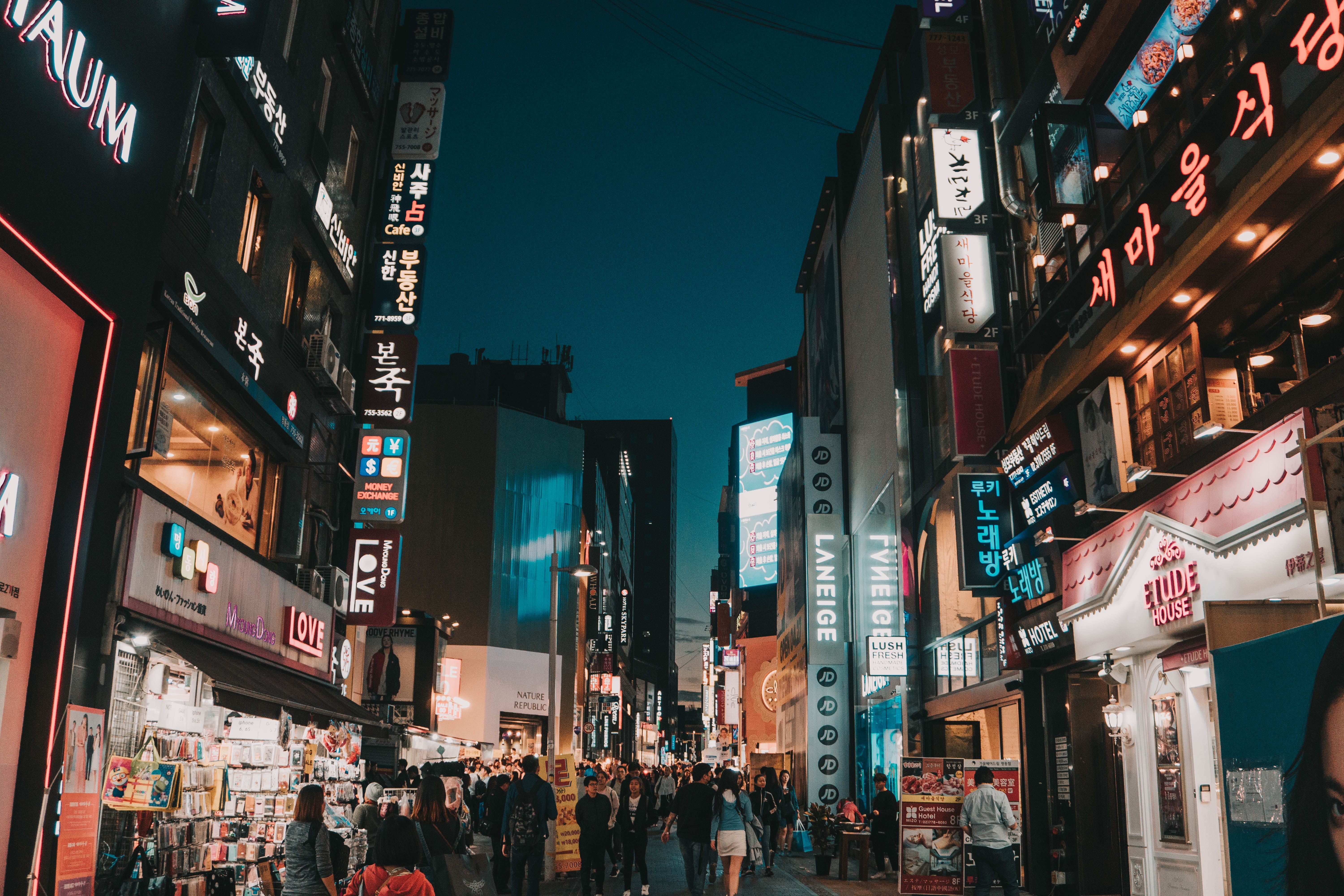 A bustling street in Seoul, South Korea at night with neon signs and people walking around. - Seoul