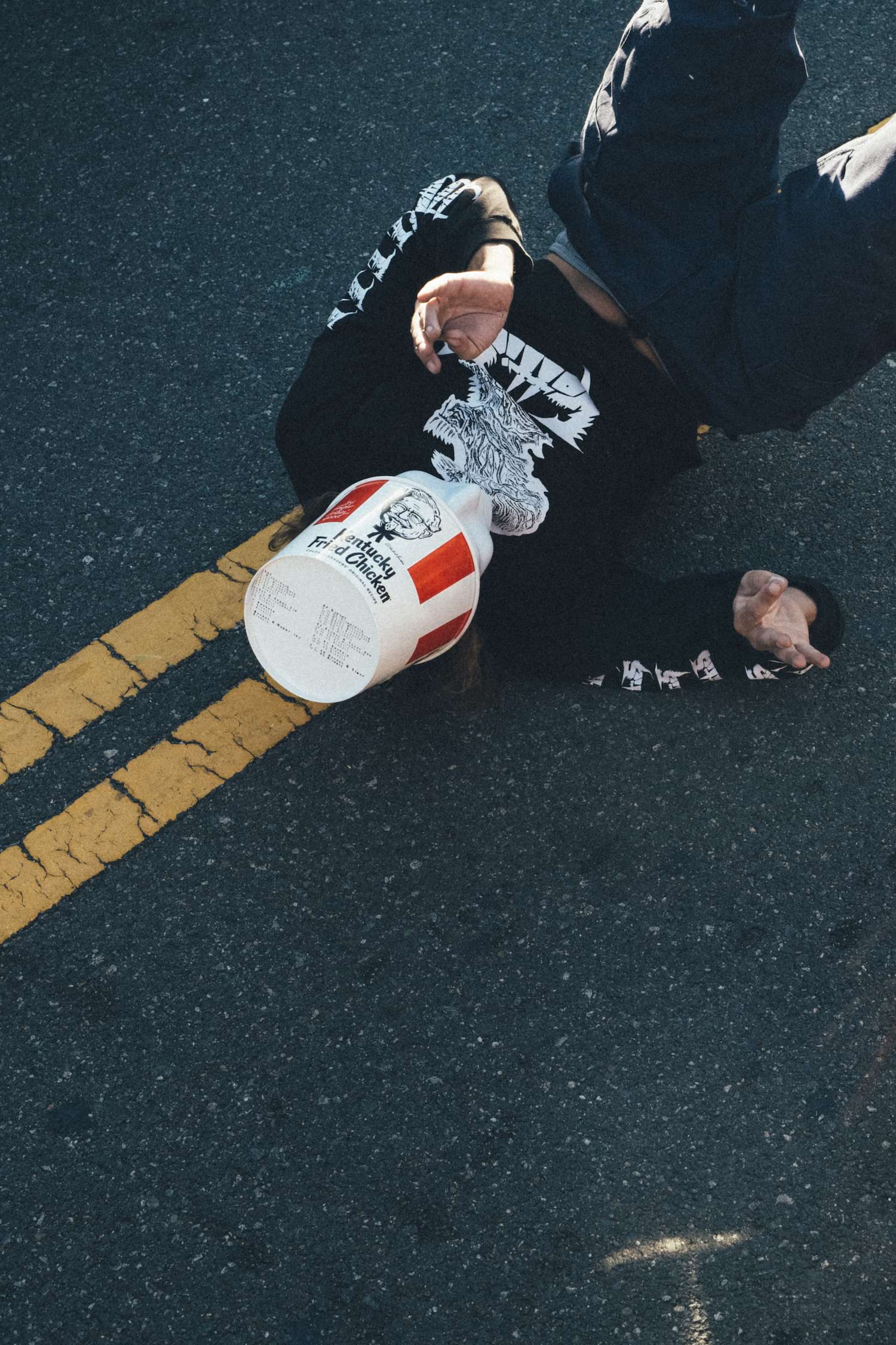 A person laying on the ground with their head in front of them - Skater