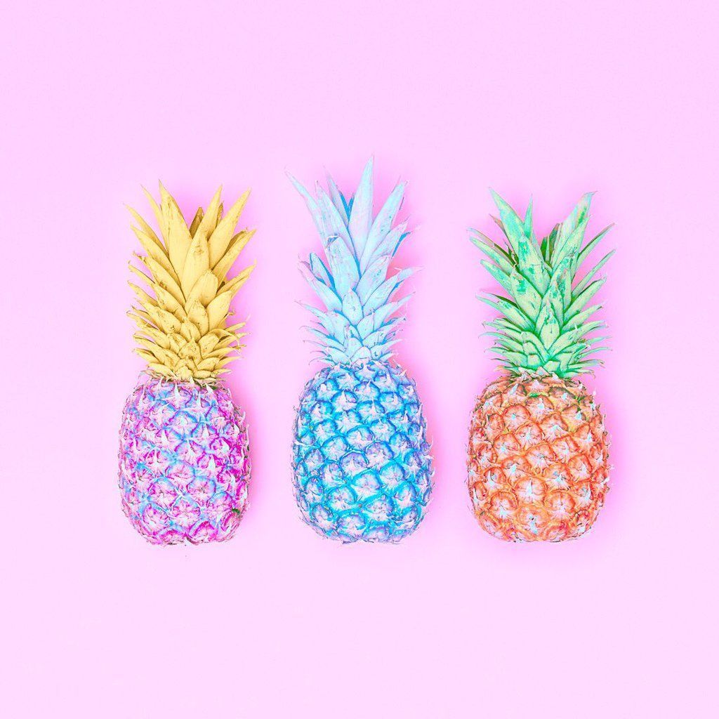 Three colorful pineapples on a pink background - Pineapple