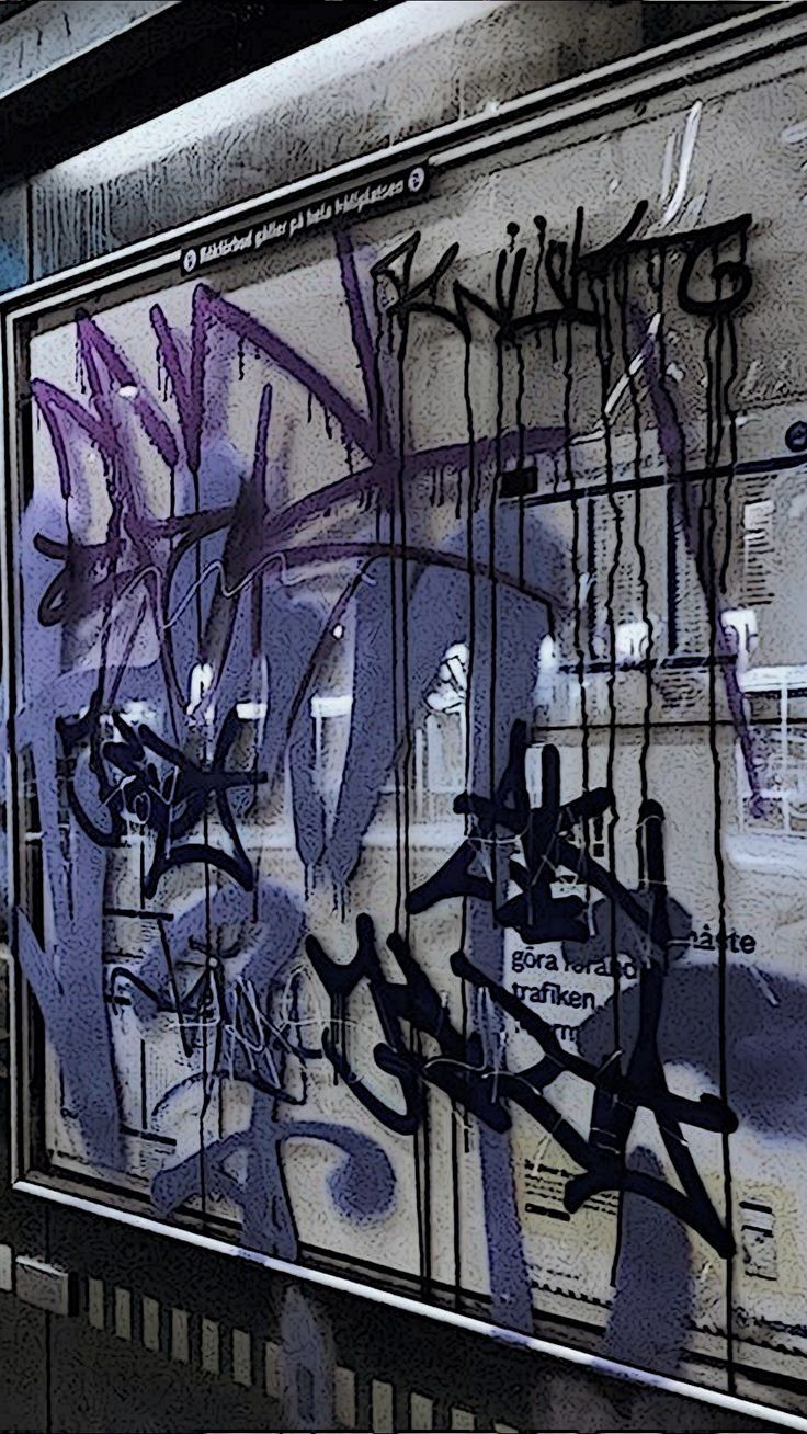 A graffiti covered window in an underground train station - Street art