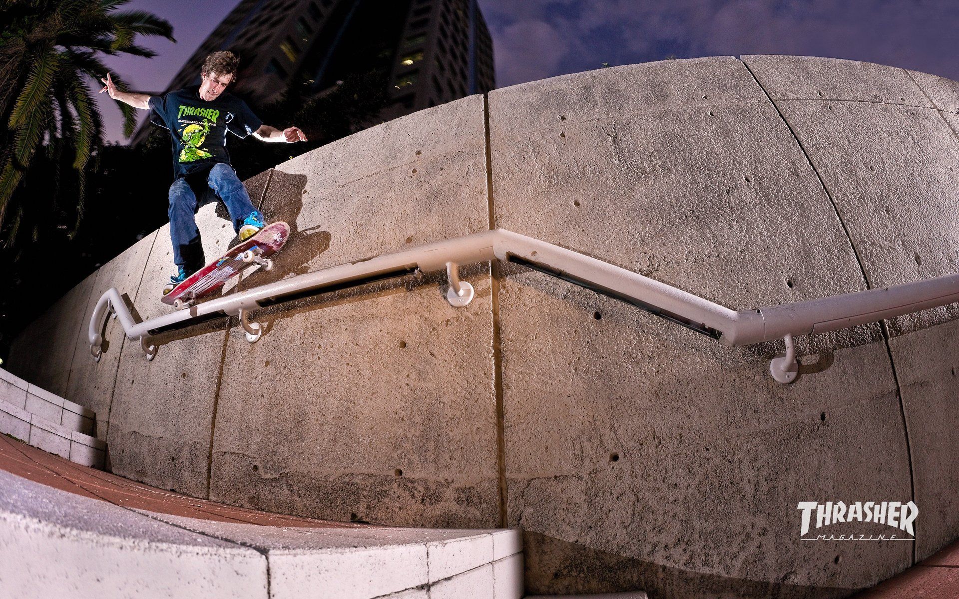 A young man riding his skateboard down the rail - Thrasher