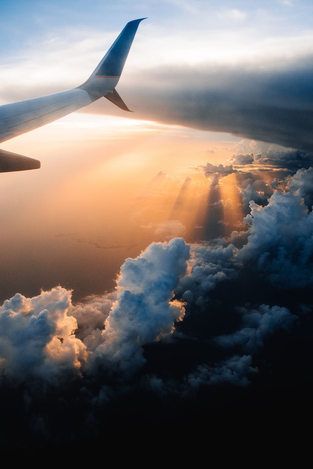 A plane wing over the clouds during sunset - Airplane