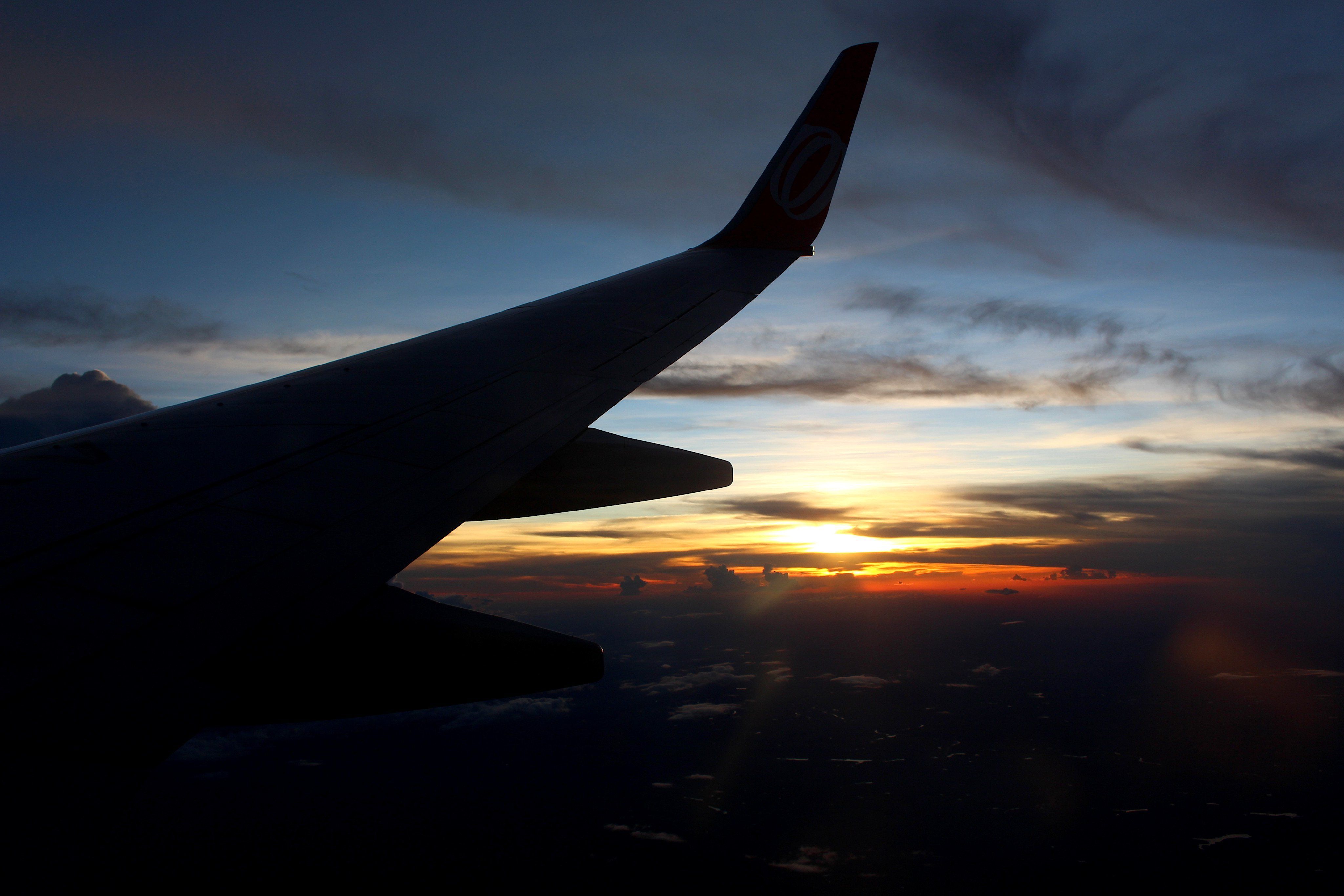 A wing of an airplane is seen at sunset - Airplane