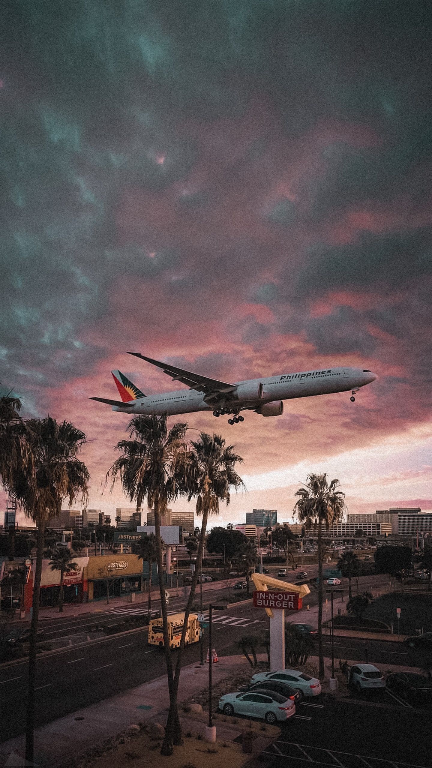 A plane flying over a city at sunset - Airplane