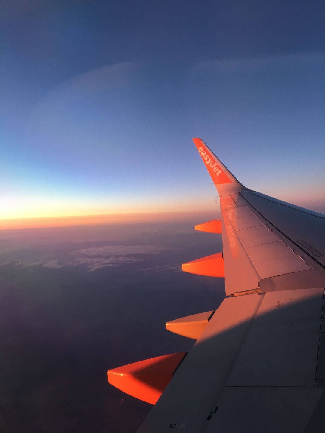 The wing of an airplane in the sky during sunset - Airplane