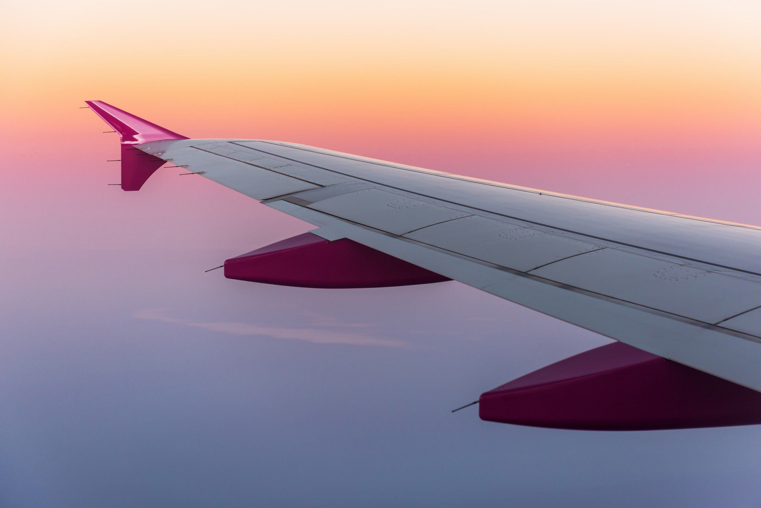 A plane wing in the sky during sunset - Airplane