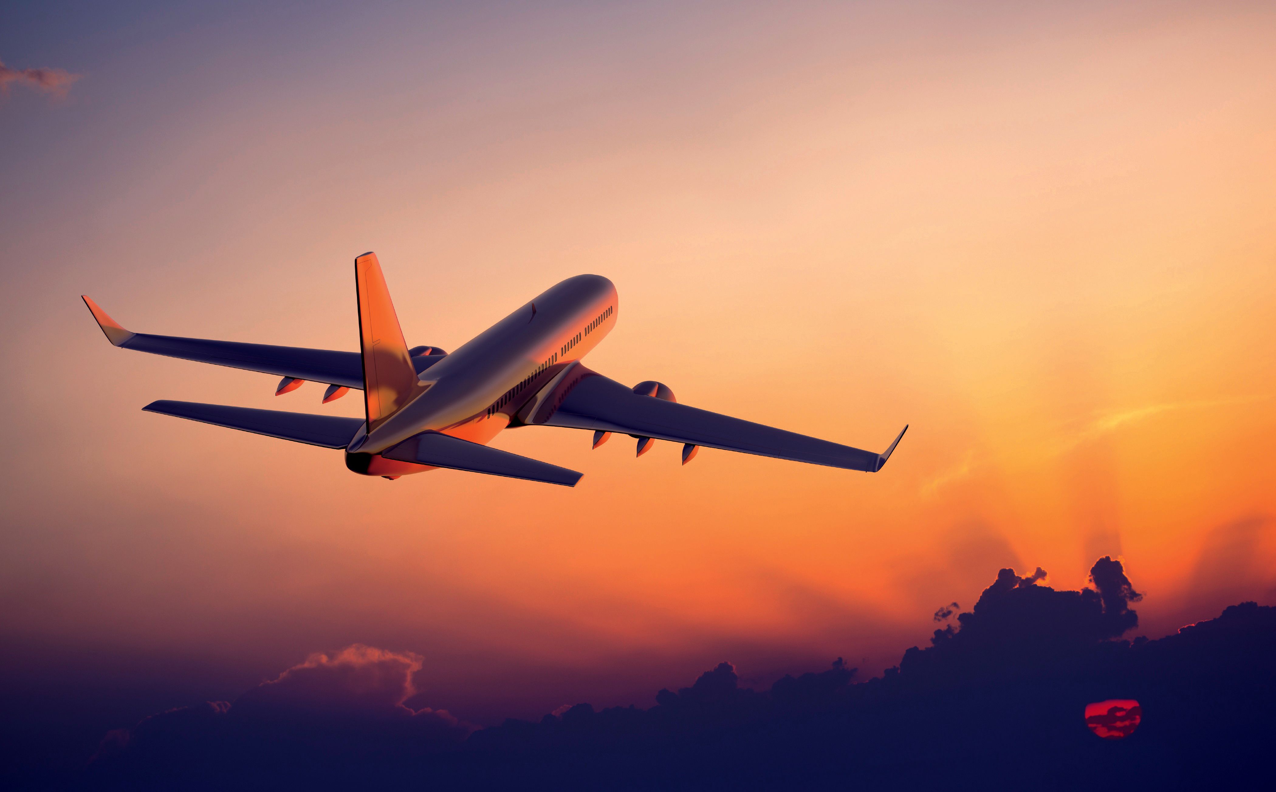 A plane flying through the sky at sunset - Airplane