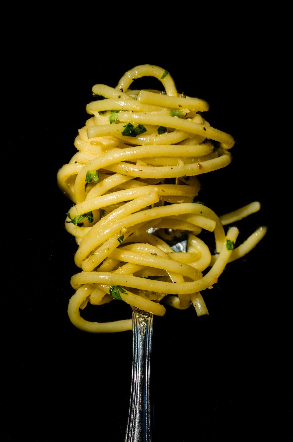 Pasta with green sauce on black background photo