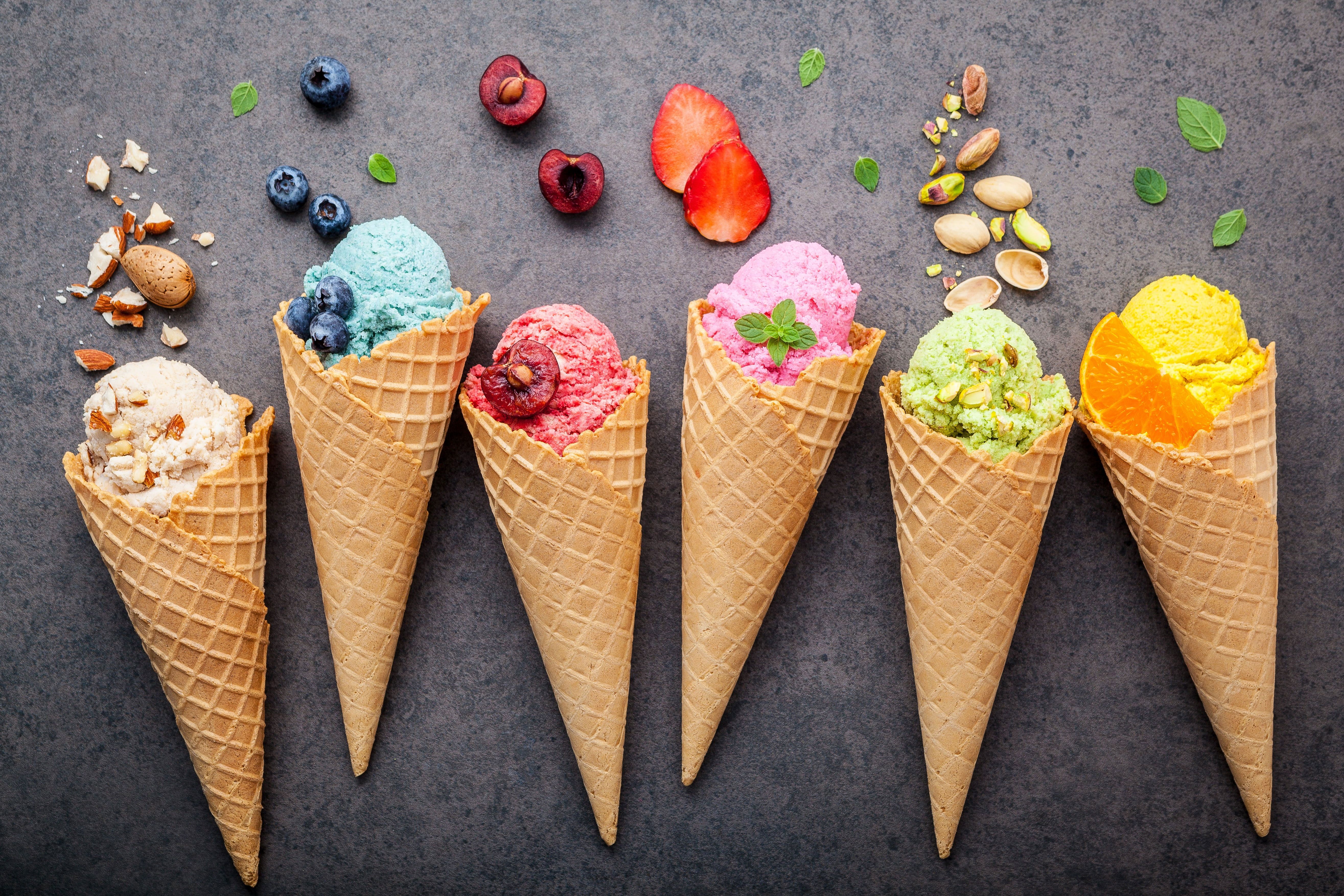 A group of ice cream cones with different toppings - Ice cream