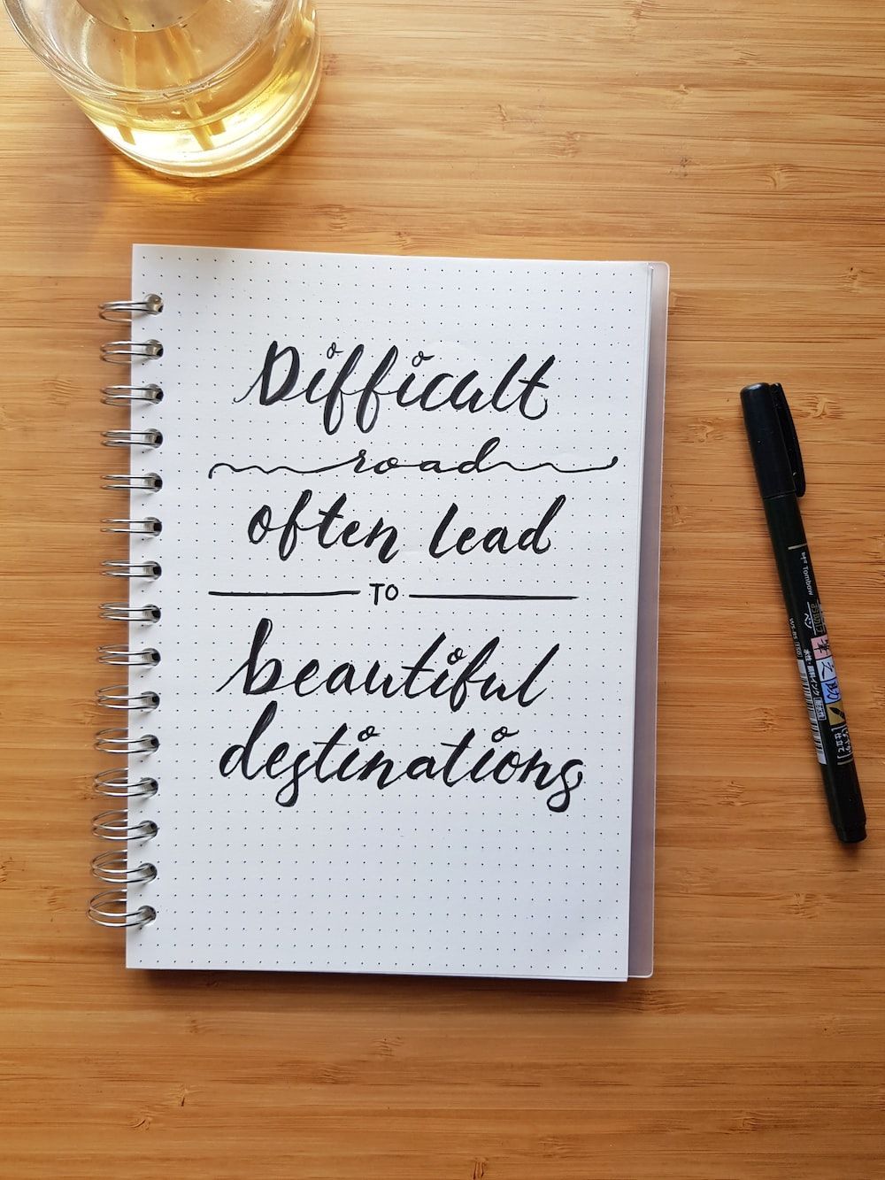 A notebook with the words different and often lead to beautiful destinations - Calligraphy