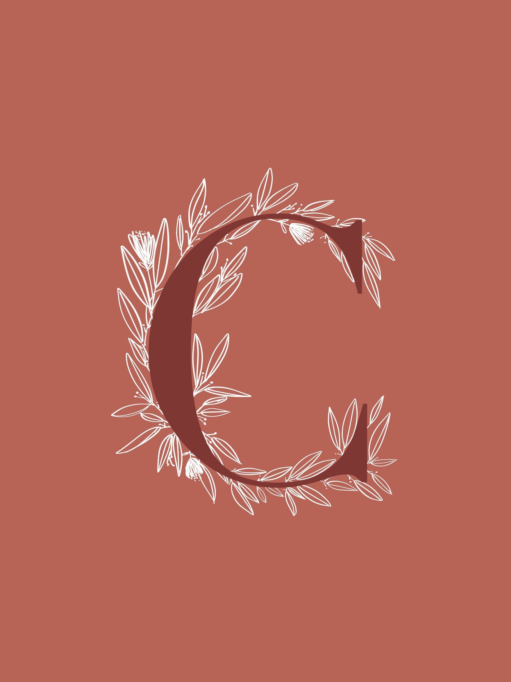 A brown letter C with a floral design on a brown background - Calligraphy
