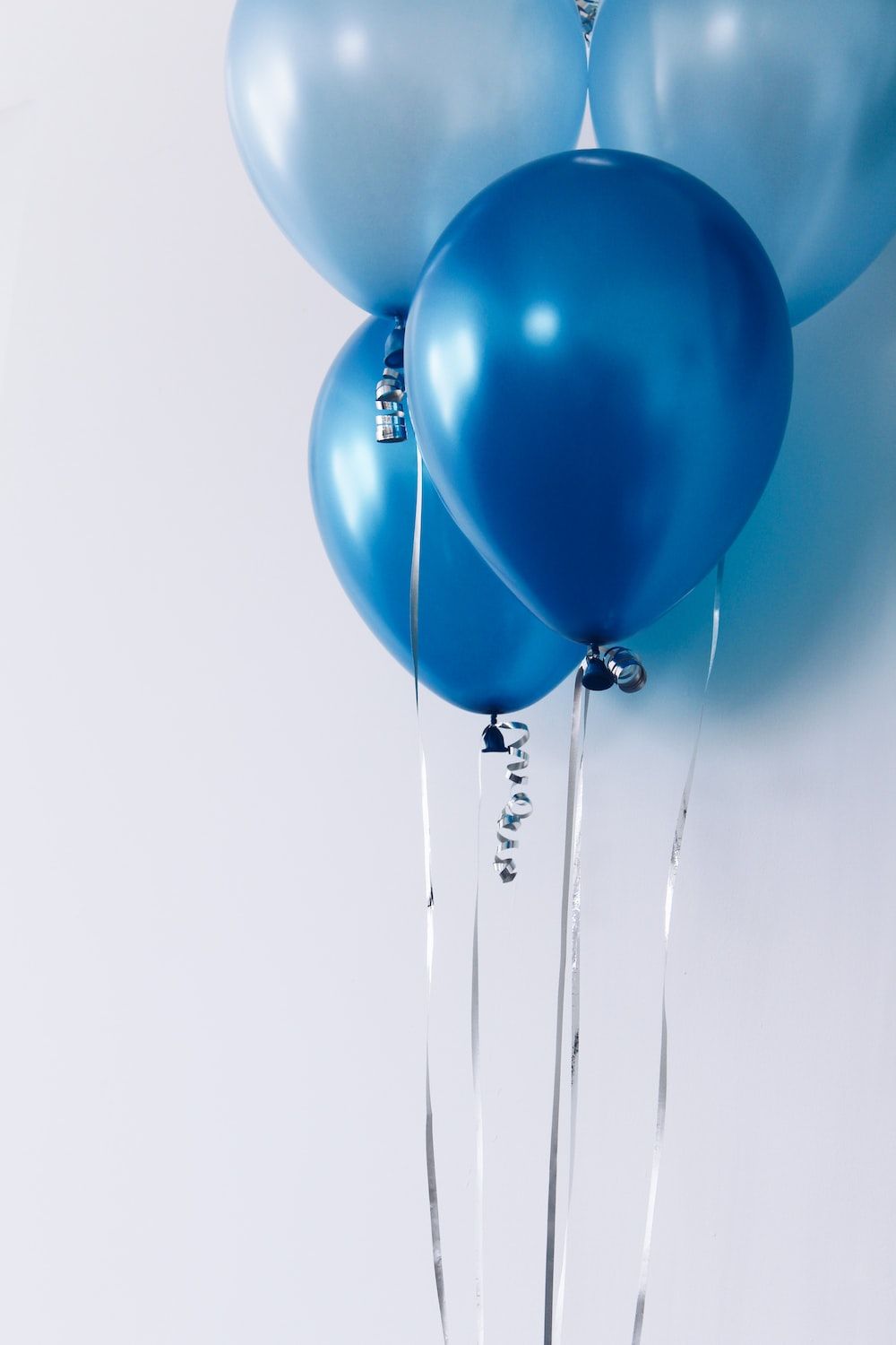 A blue balloon with silver ribbon is hanging - Balloons