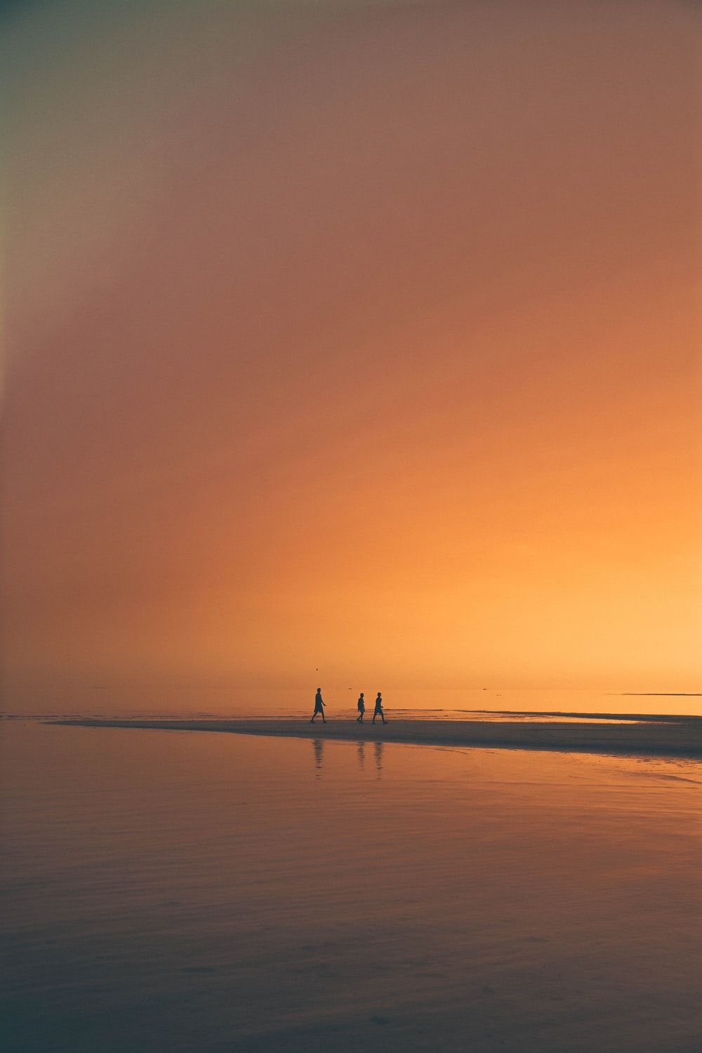 A group of people walking on the beach - Sunrise