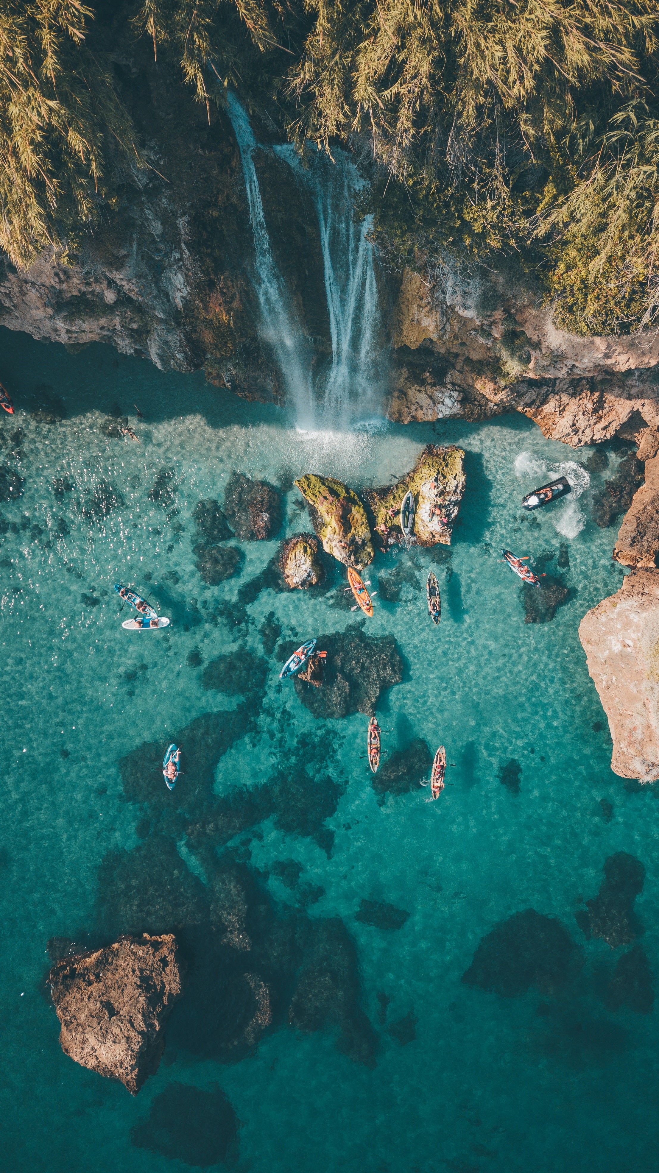 A waterfall and people in the ocean - Waterfall