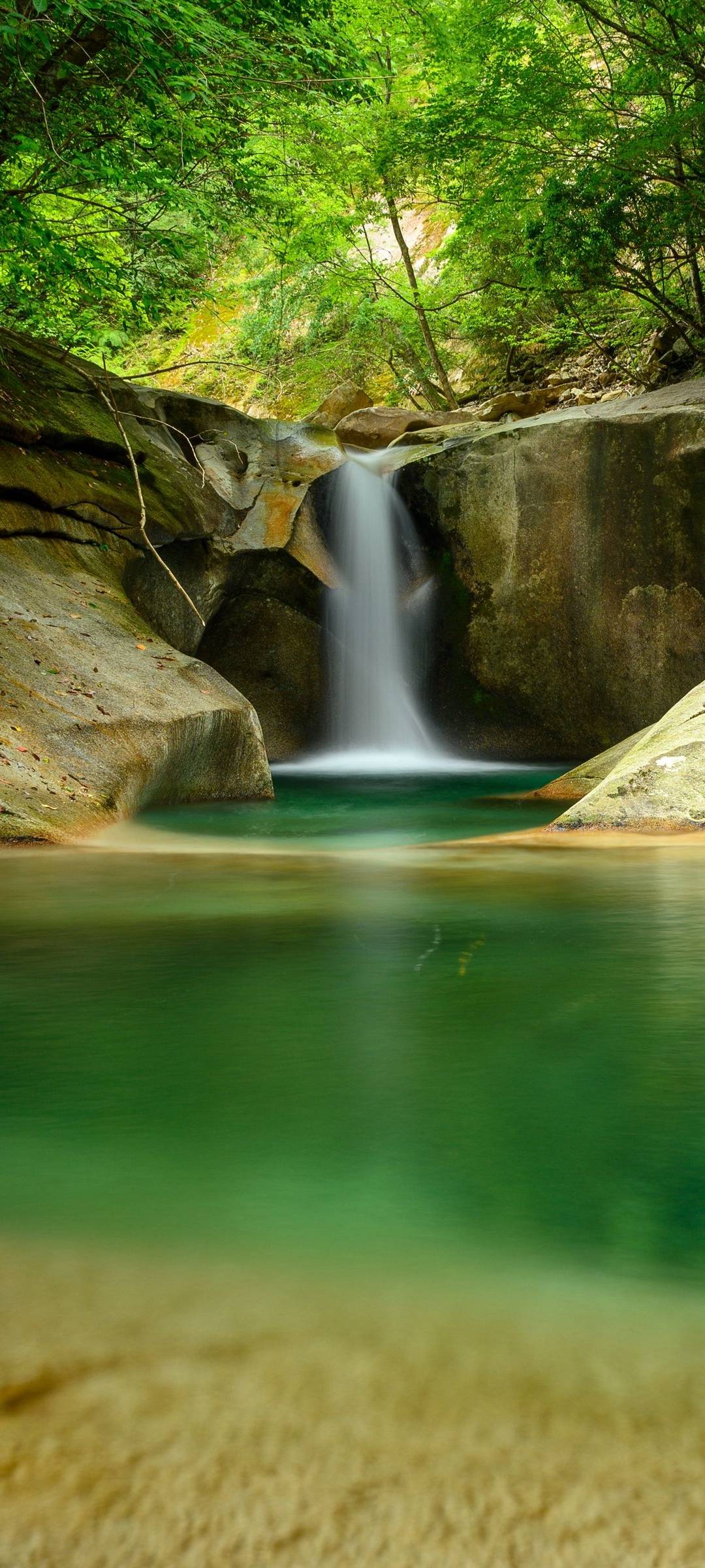 A waterfall in the middle of some trees - Waterfall