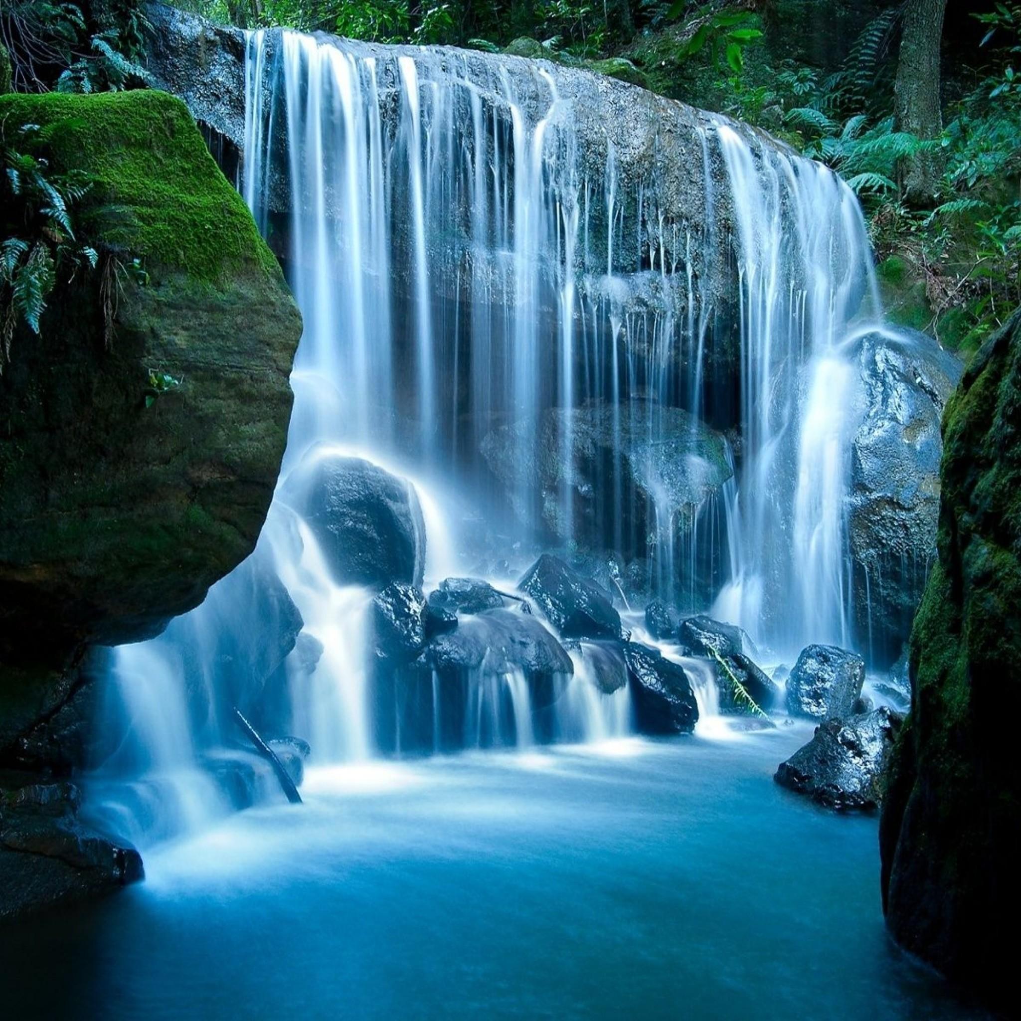 A waterfall in the middle of some rocks - Waterfall