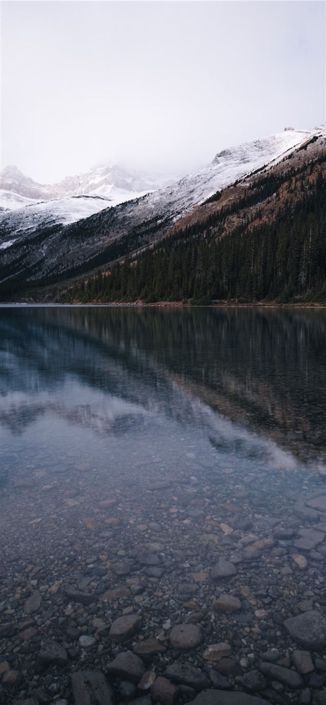 A lake with snow covered mountains in the background - Lake