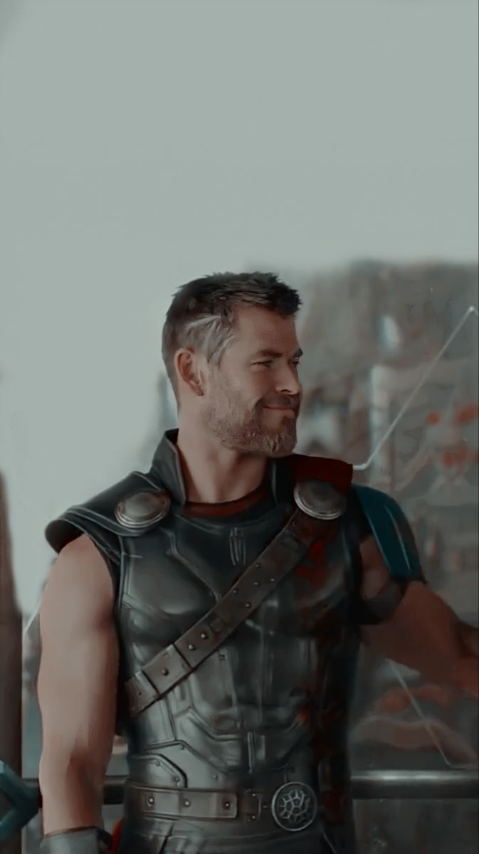 A man in armor standing next to an open door - Thor