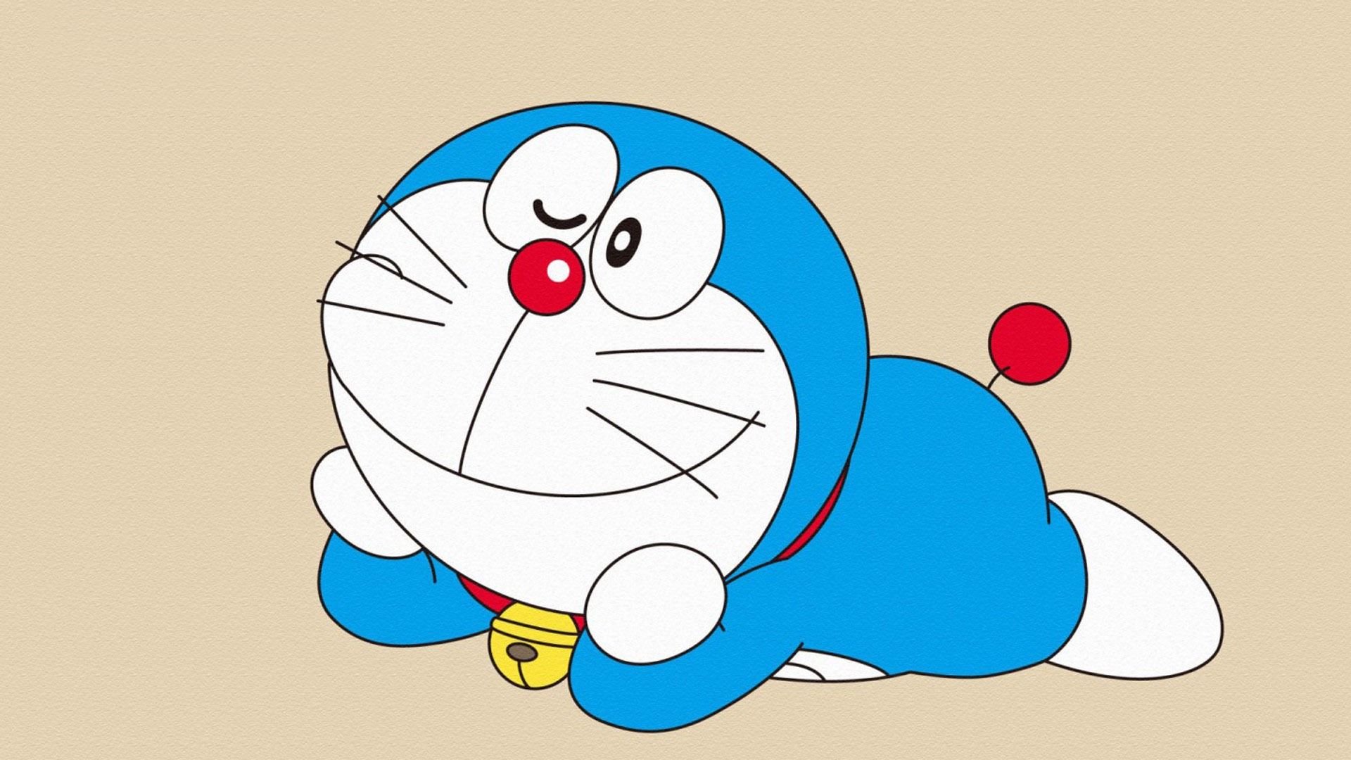 A blue and white cartoon character is laying down - Doraemon