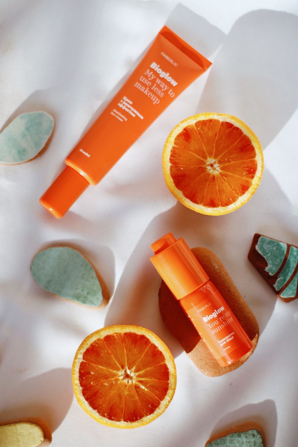 Two orange Skingredients skincare products next to orange slices on a white background - Orange