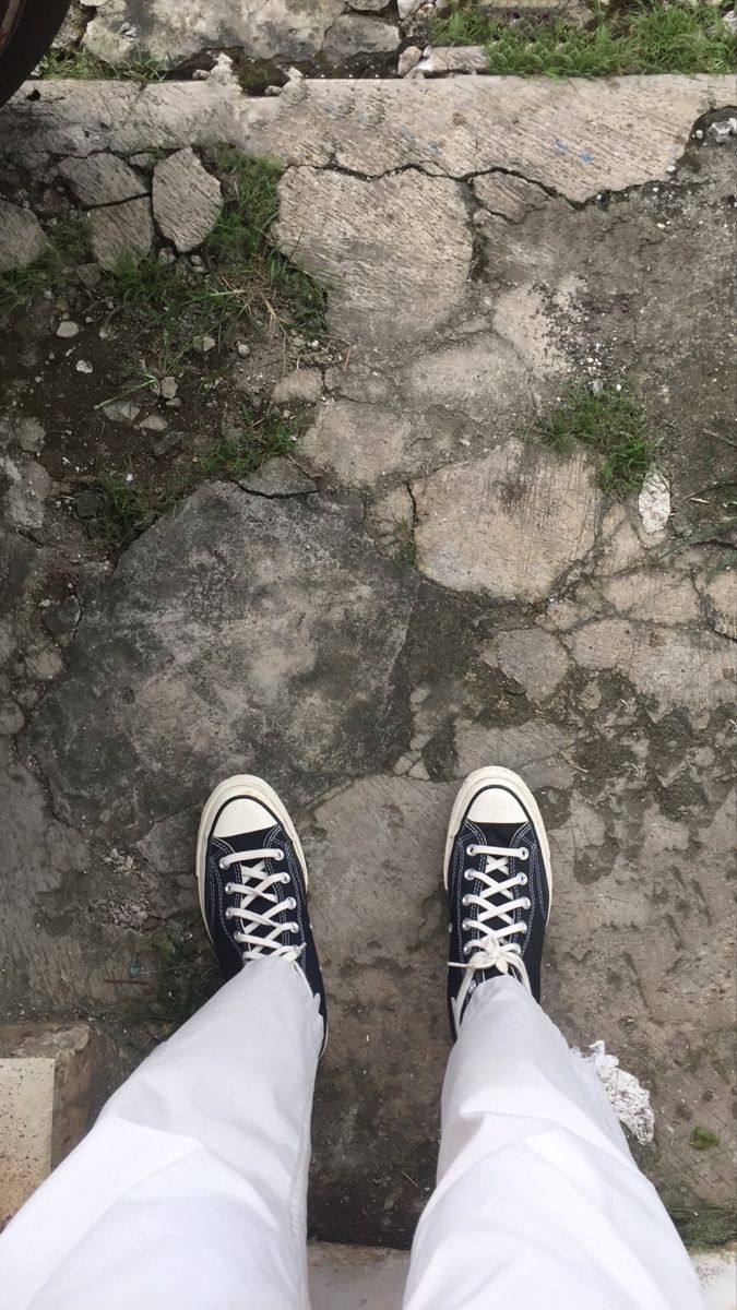 A person standing on the steps of an old building - Converse