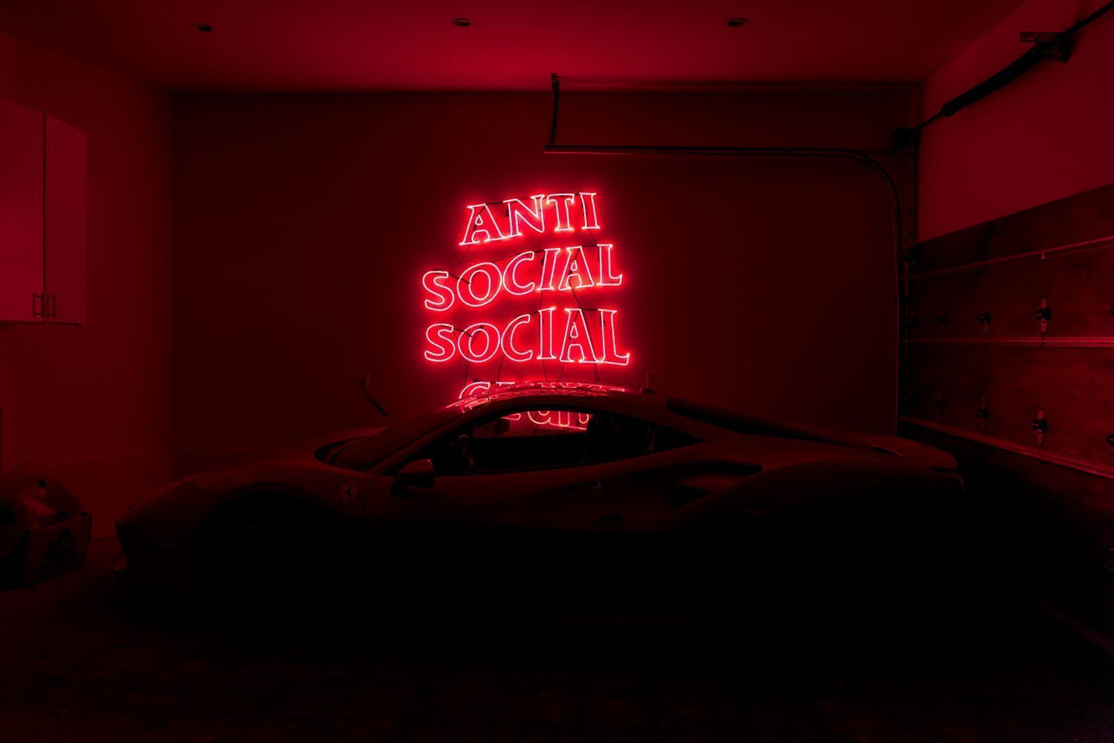 A red neon sign that says anti social - Anti Social Social Club