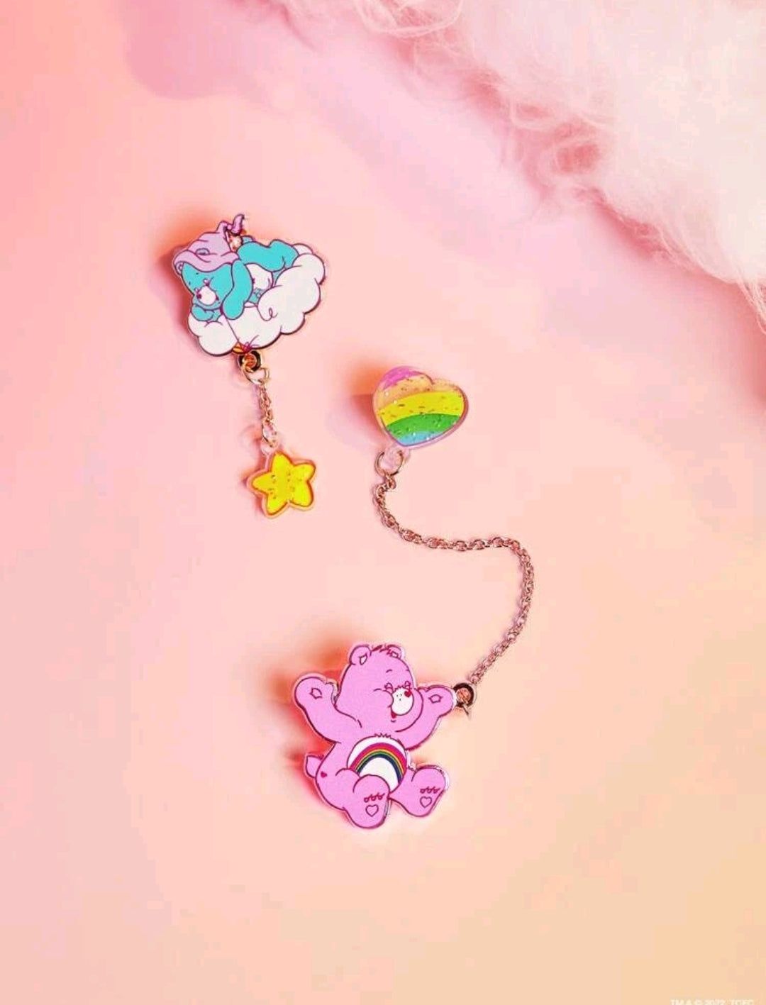 A pair of pins with cartoon characters on them - Care Bears