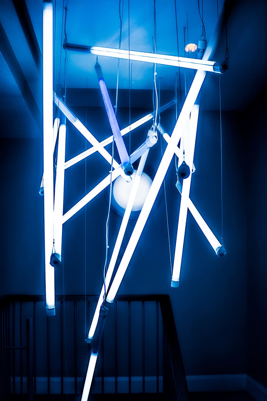 A blue light installation hanging from the ceiling. - Geometry
