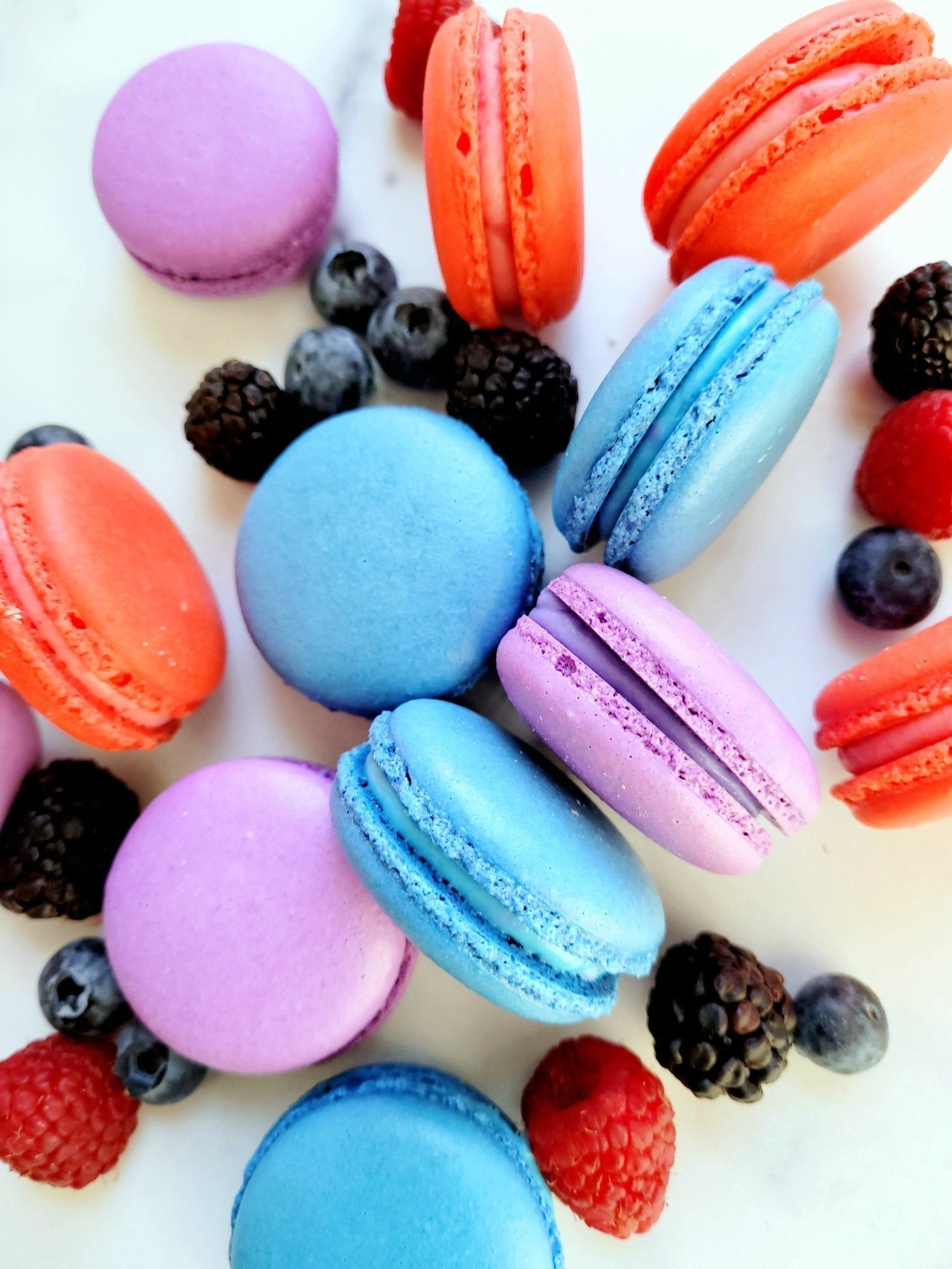 A plate of colorful macarons and berries - Bakery