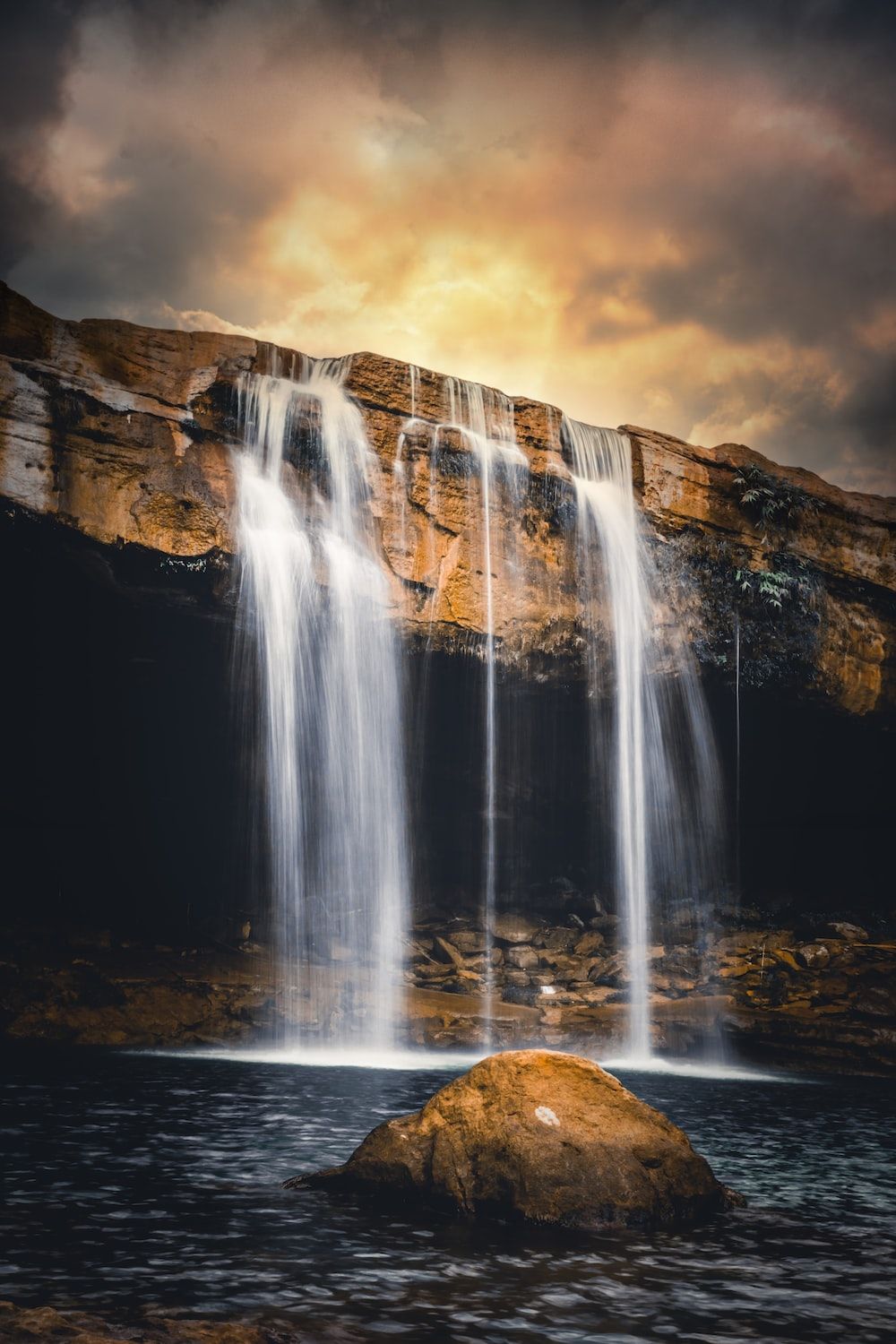 A waterfall with rocks and trees - Waterfall