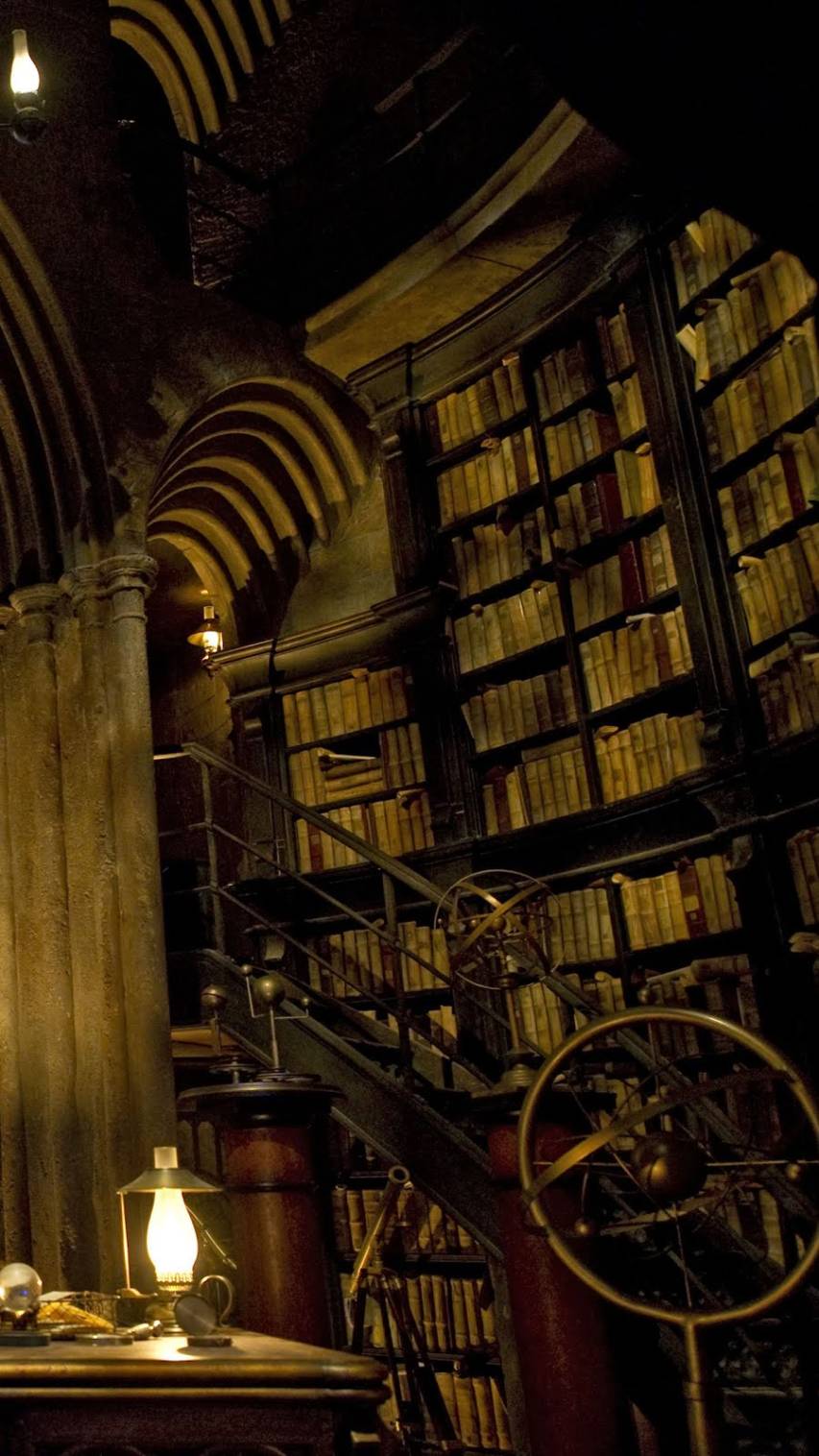 The interior of the Hogwarts library, with bookshelves stretching up to the ceiling and a winding staircase - Hogwarts, Harry Potter