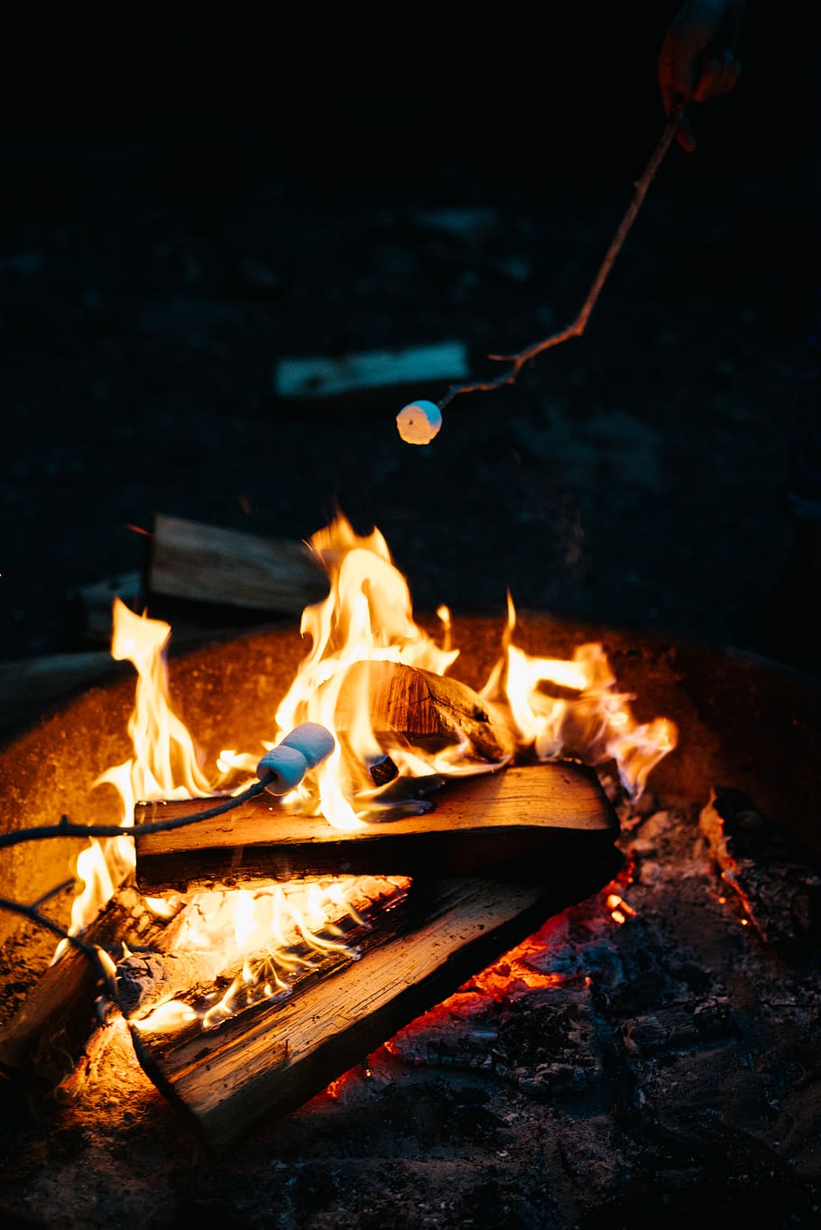 A marshmallow roasting over a campfire. - Marshmallows