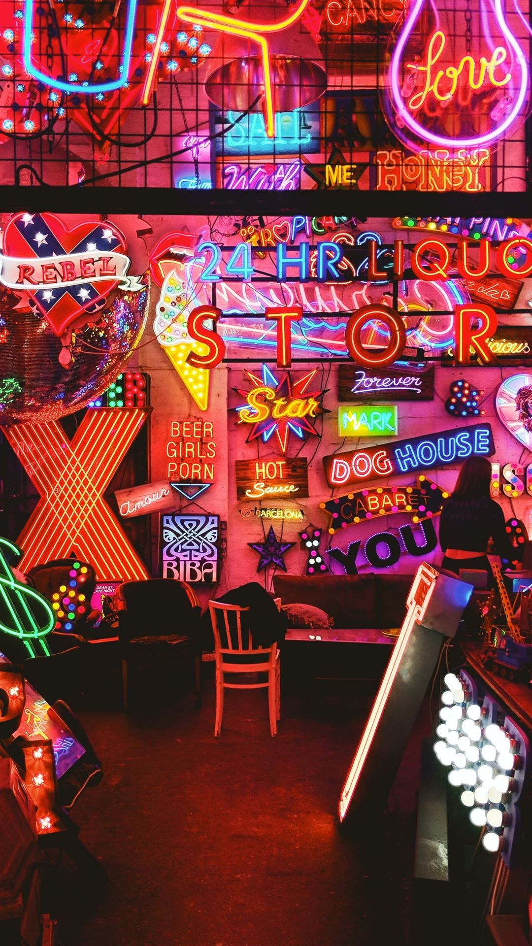 A neon sign room with a chair and tables - Arcade