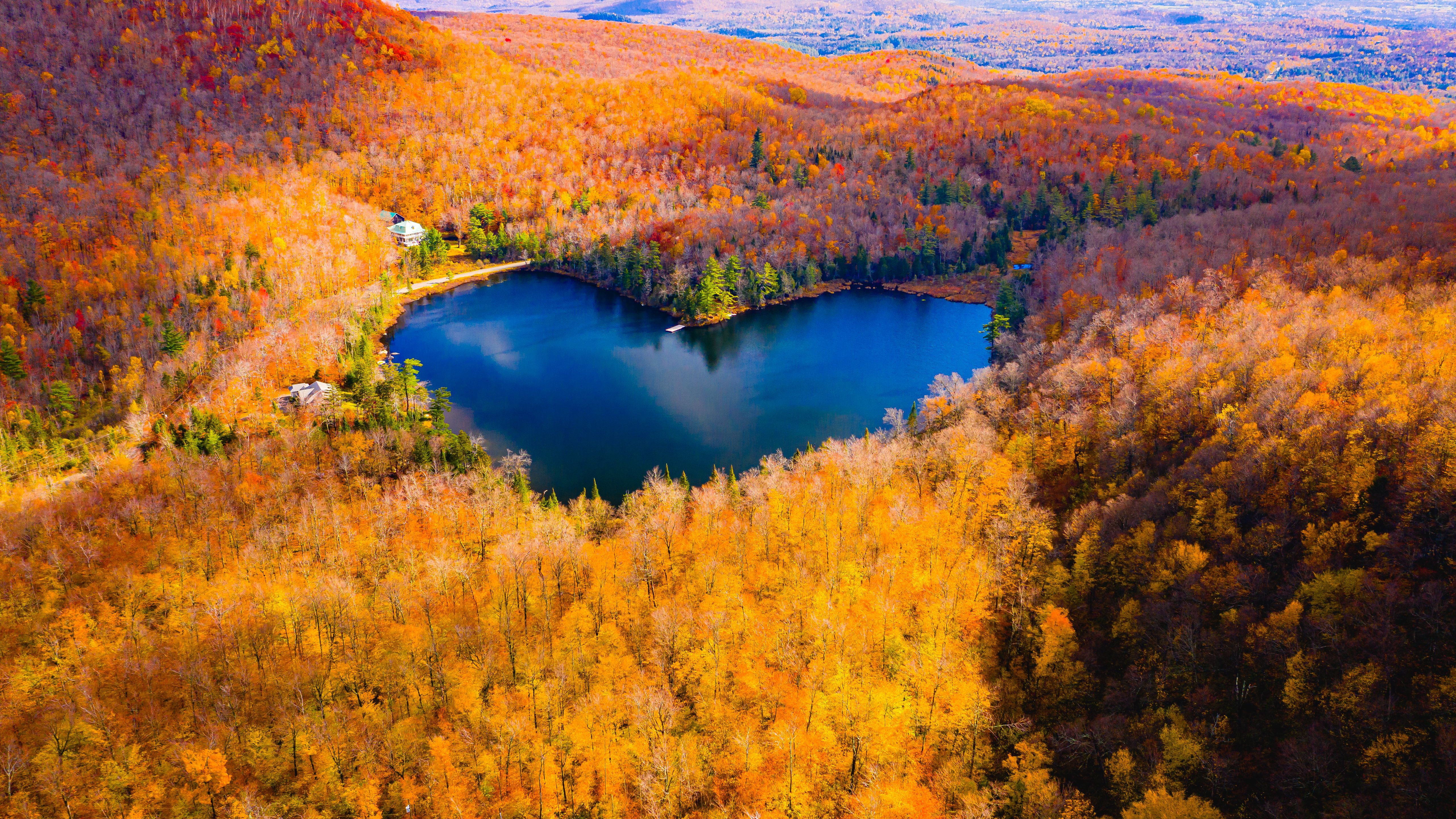 A heart shaped lake surrounded by trees in the fall - Lake