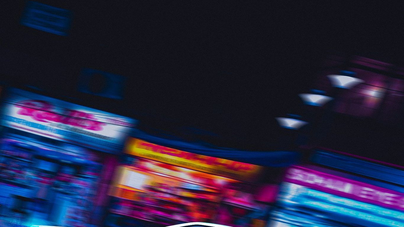 An abstract image of a city at night with neon lights - 1366x768