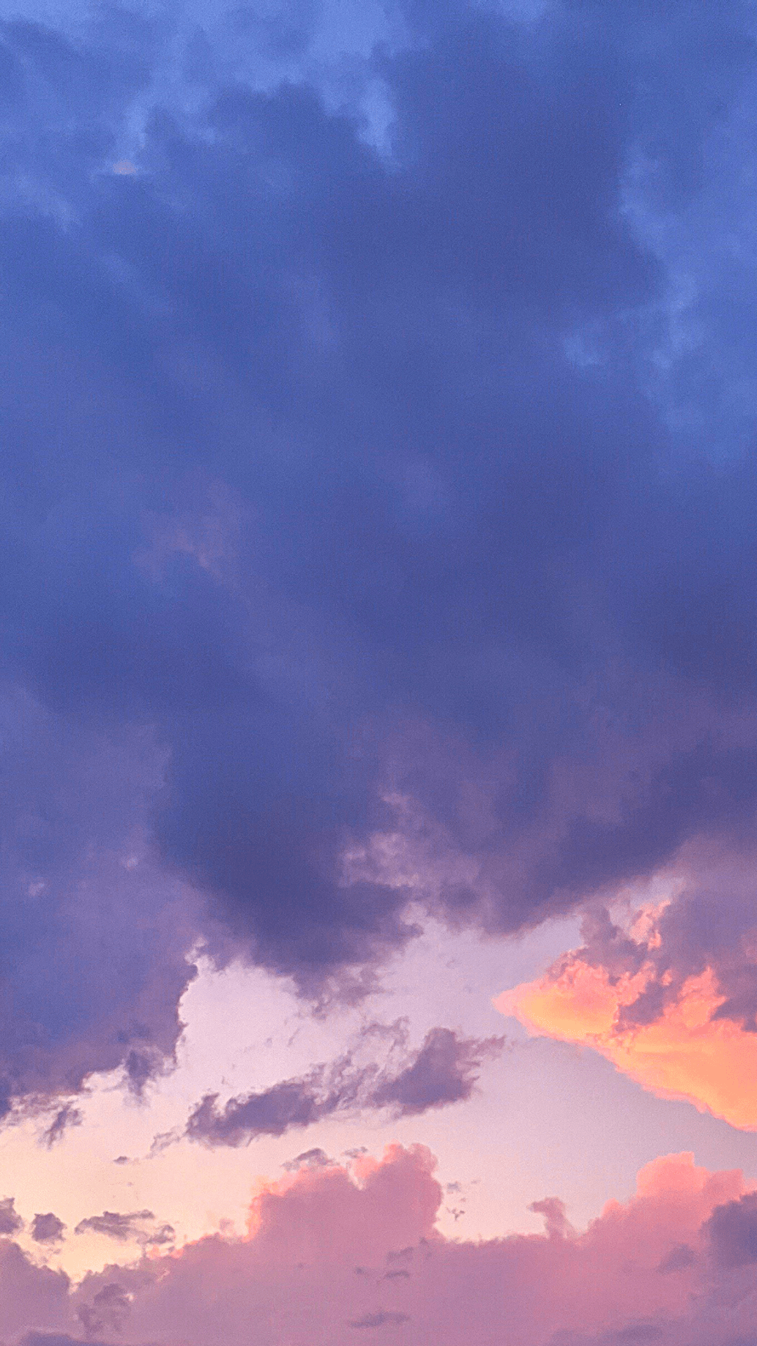A sky during sunset with a mix of blue, purple, and orange clouds. - Sunset