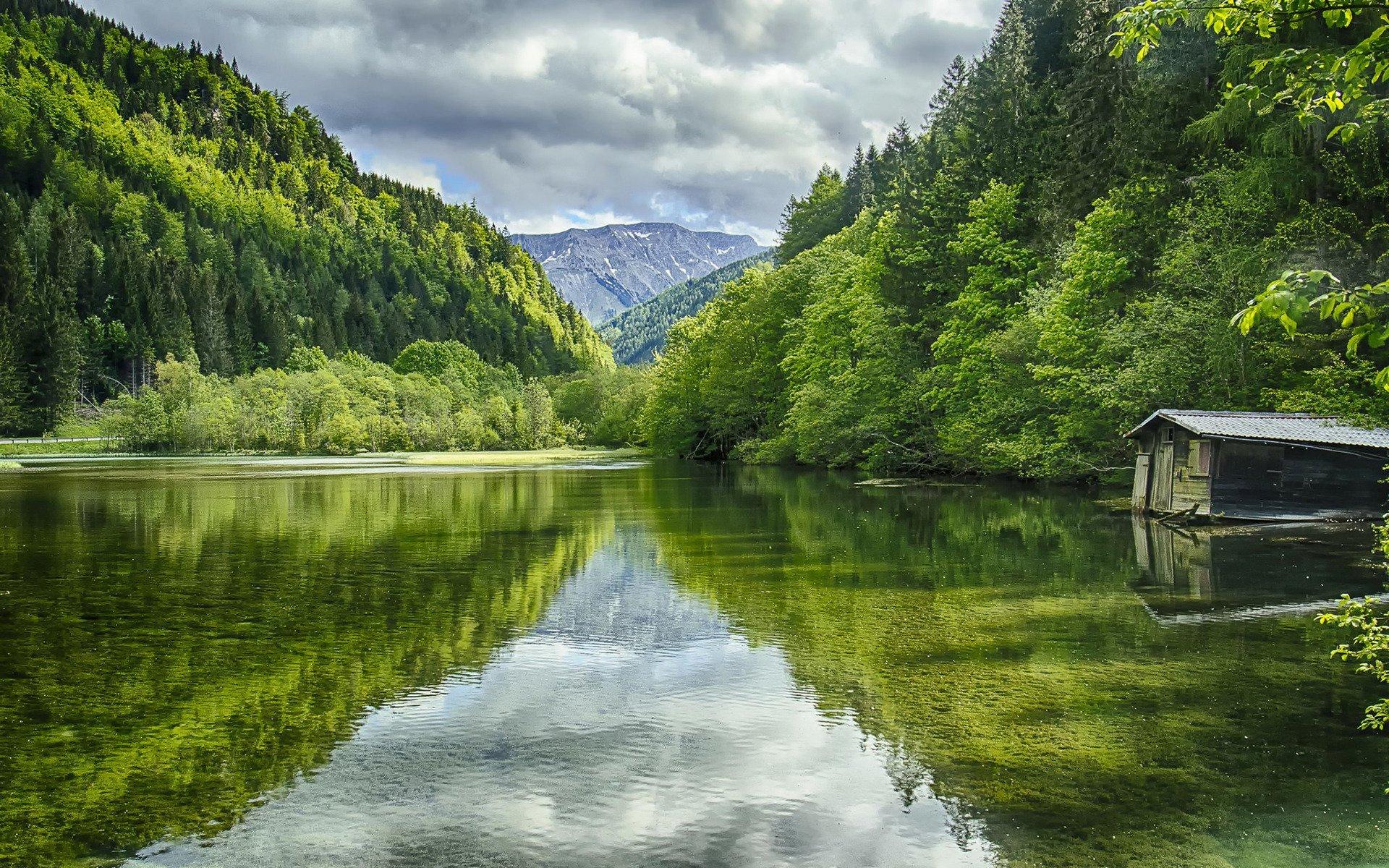 A beautiful view of a lake surrounded by trees and mountains. - River