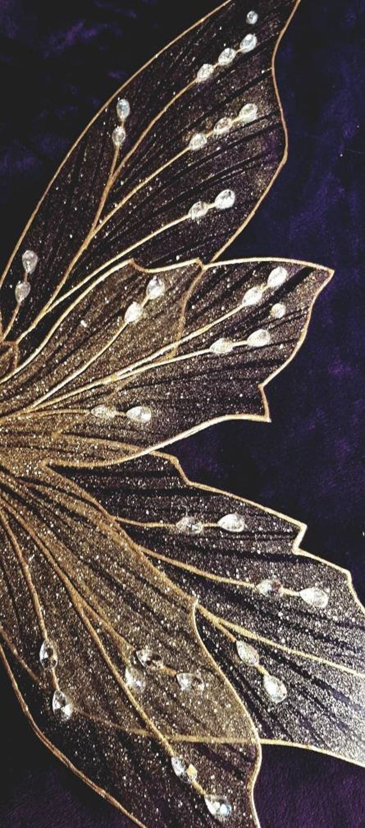 Close up of a gold and black fairy wing with rhinestones - Wings
