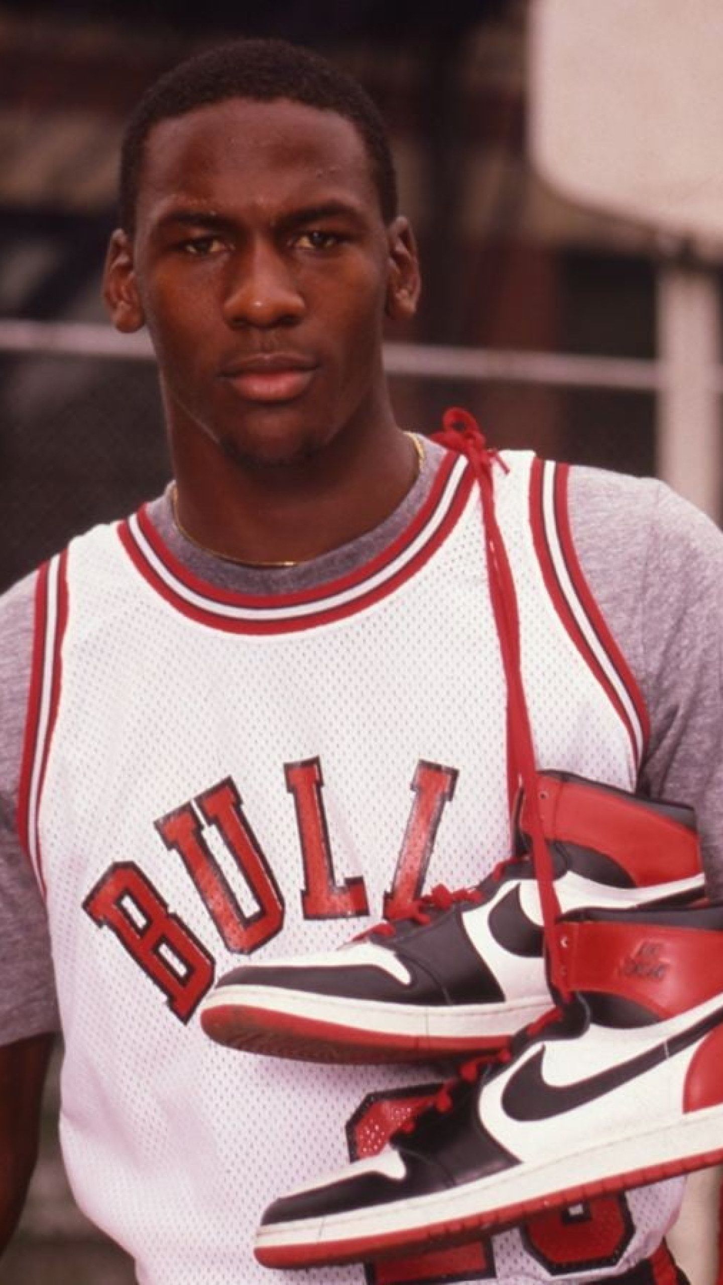 Michael Jordan holding a pair of his signature sneakers. - Air Jordan, Michael Jordan