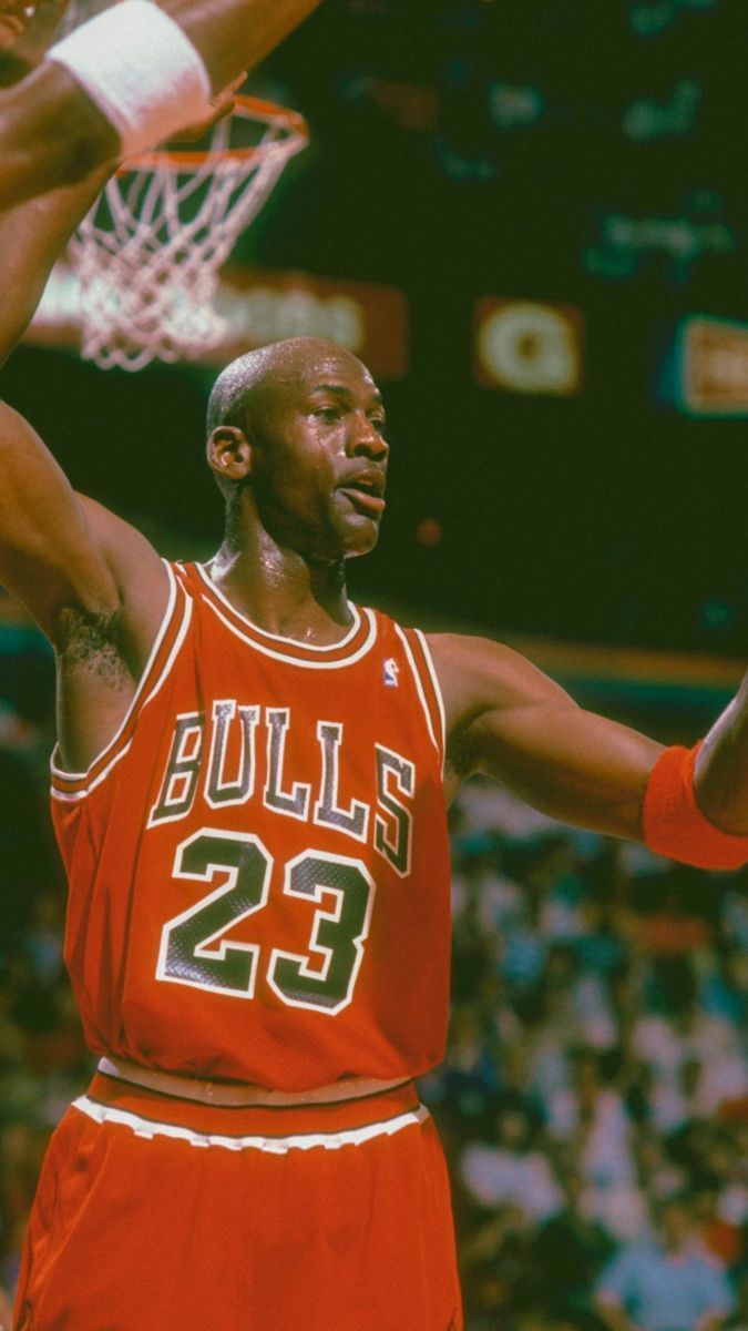 Michael Jordan in his Chicago Bulls jersey, holding a basketball above his head. - Michael Jordan, Air Jordan