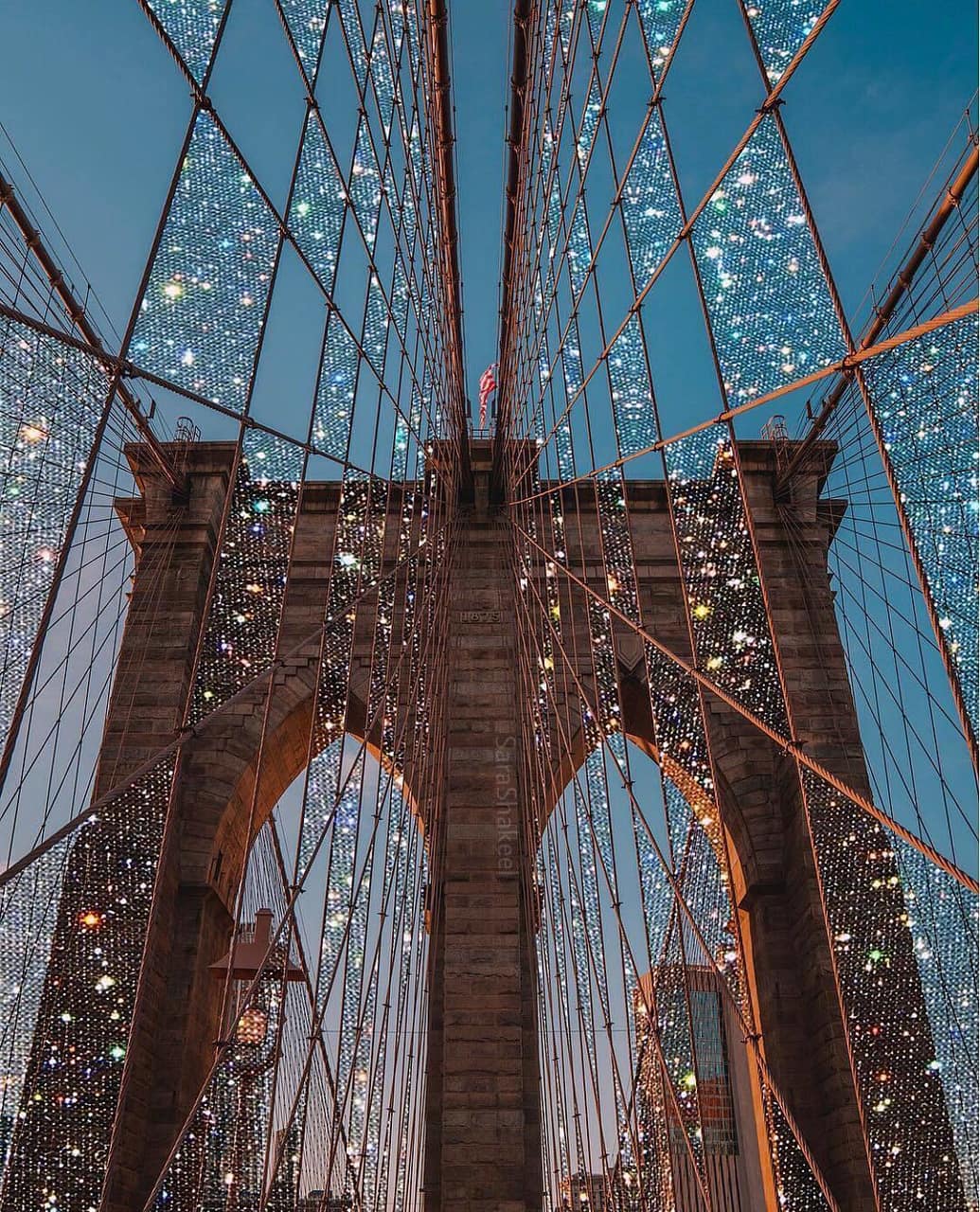 Brooklyn Bridge lit up with lights in the night - City