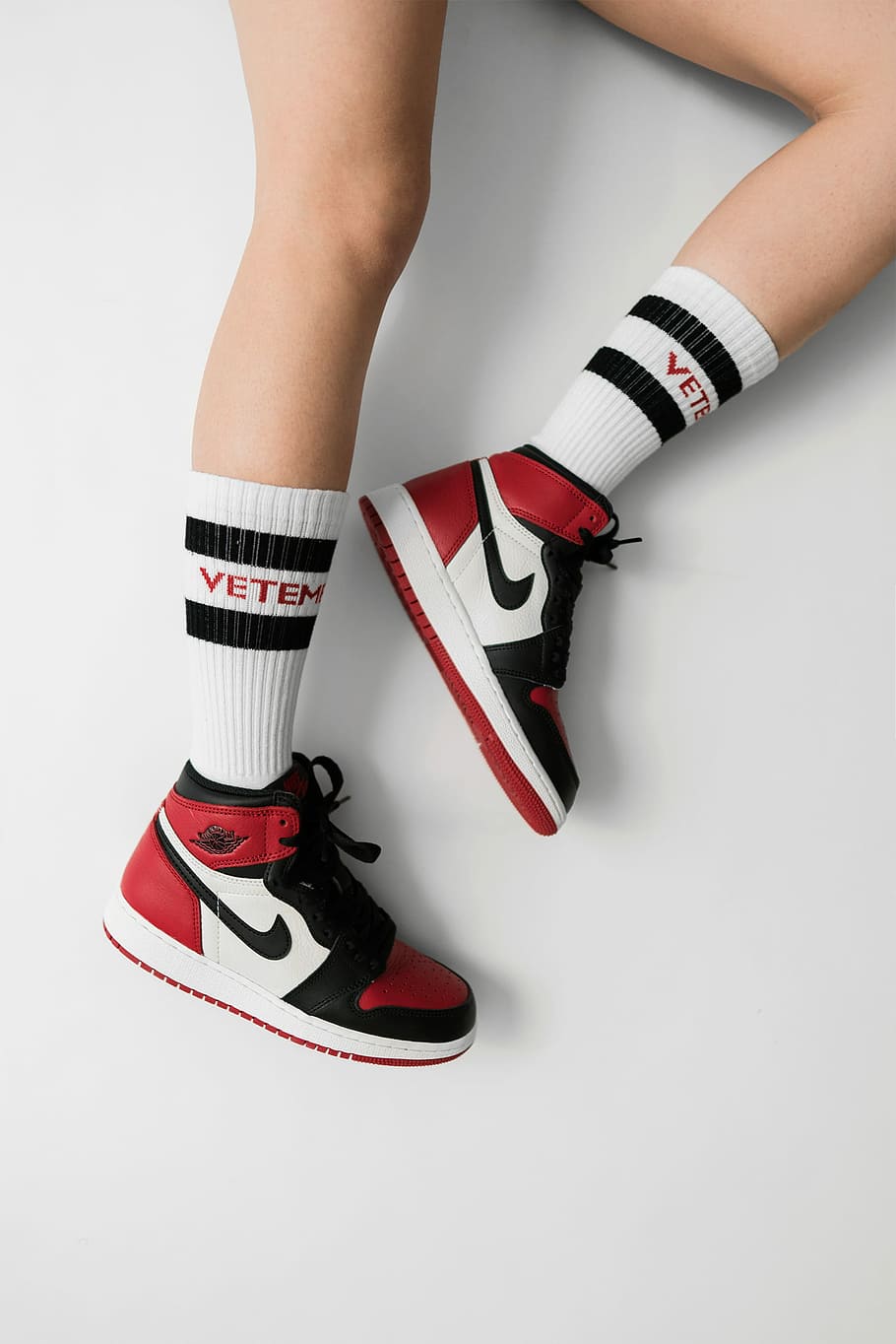 Model wearing black and white striped socks with the words Vetements on them - Air Jordan 1