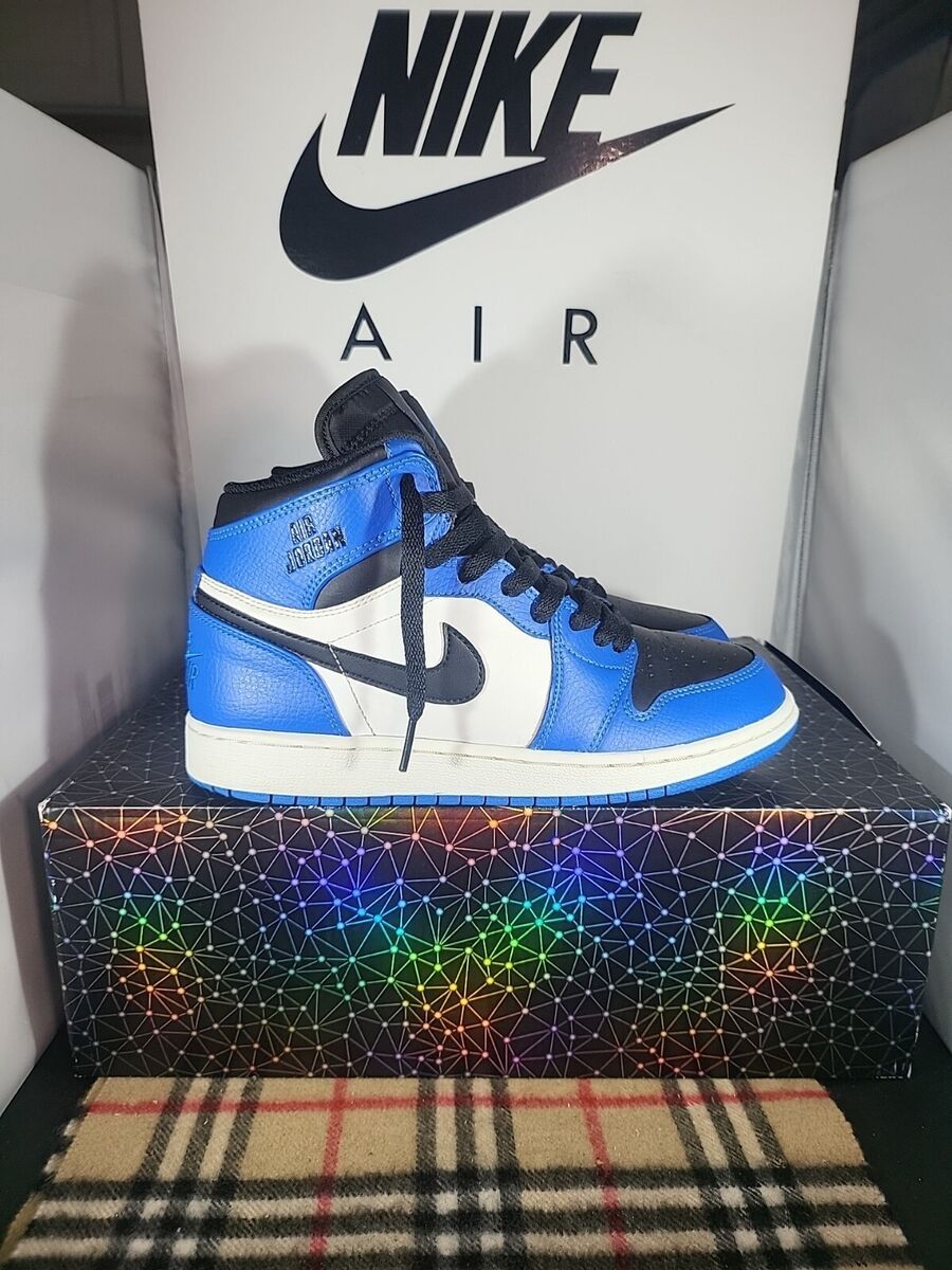A pair of blue and black Nike shoes on a black box - Air Jordan 1