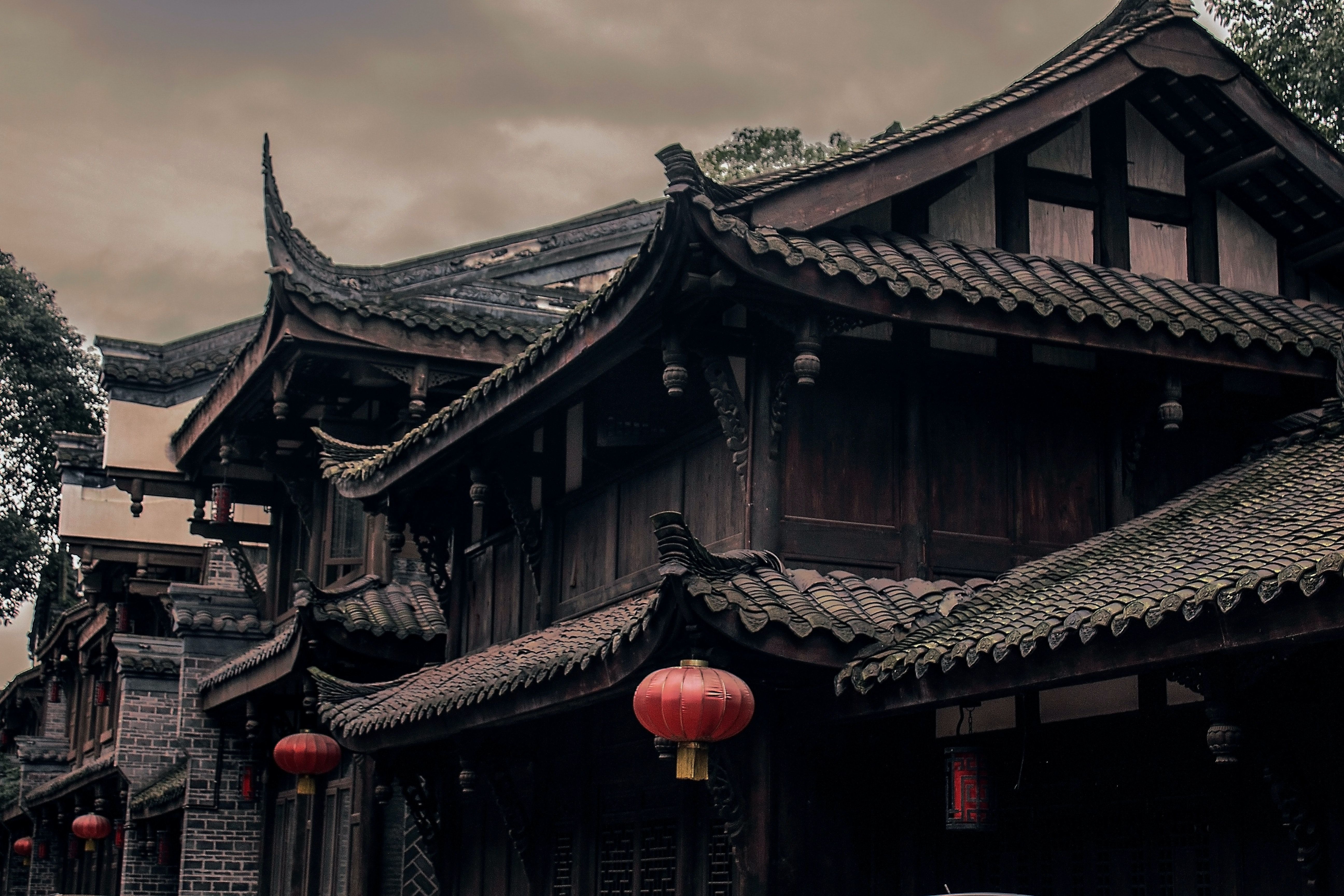 A Chinese style building with red lanterns hanging from the roof. - Chinese