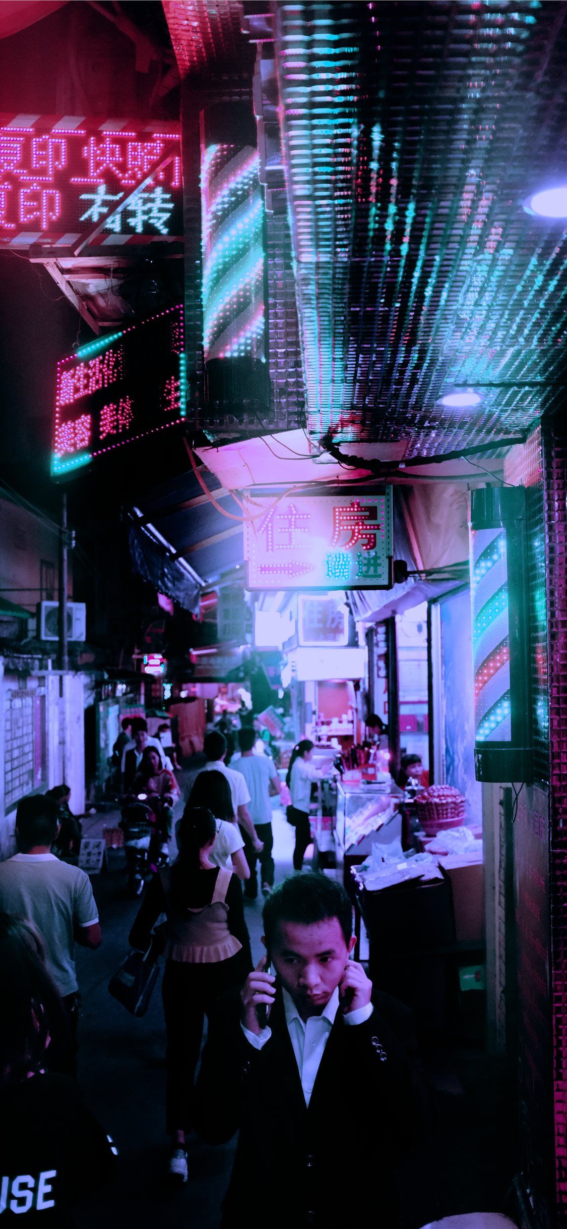 A busy street in China with people walking around and neon signs - Chinese