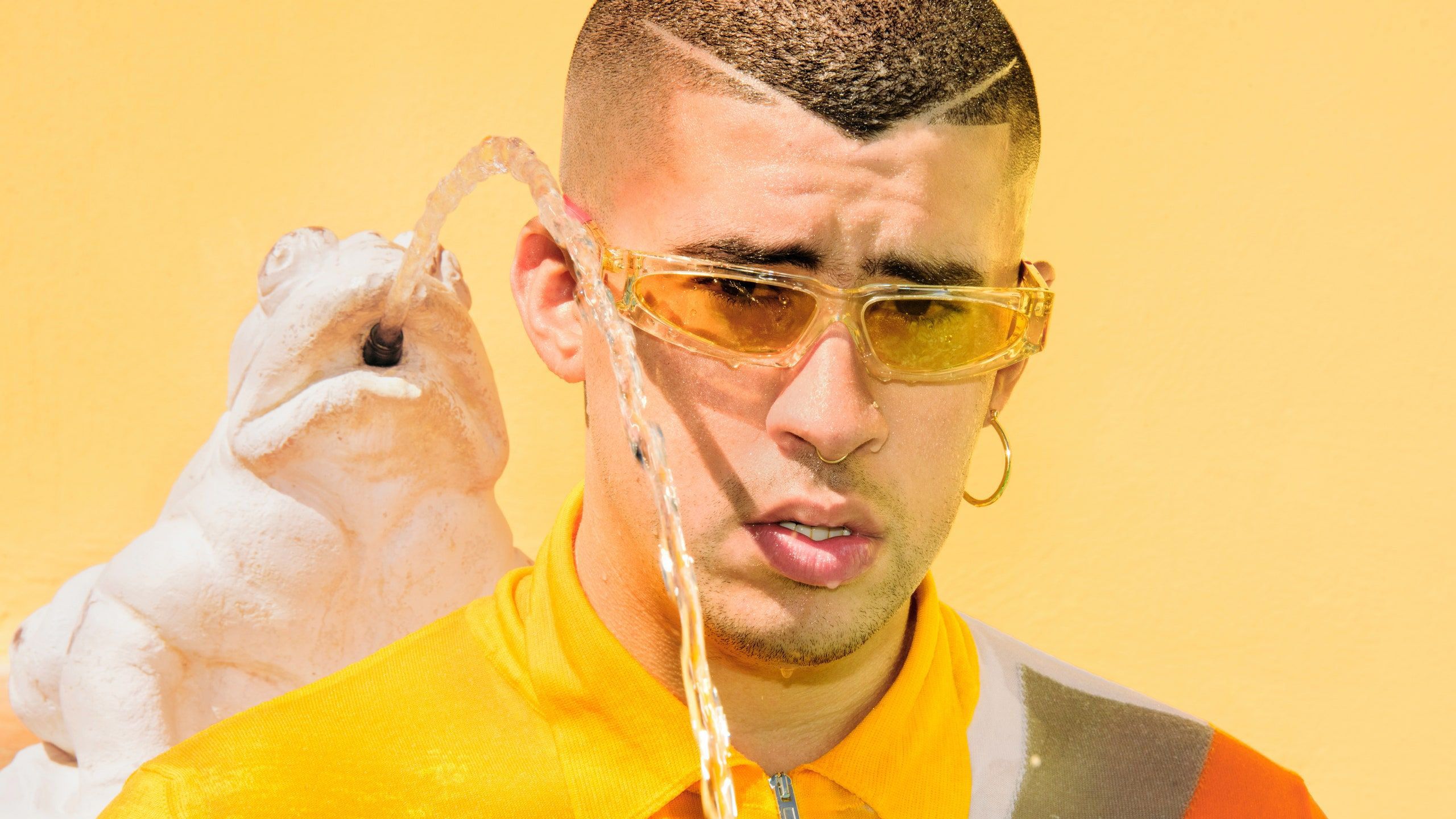 Bad Bunny Aesthetic In Yellow Background Wearing Yellow Dress And Sunglases With Water Spitting Frog Backside HD Music Wallpaper