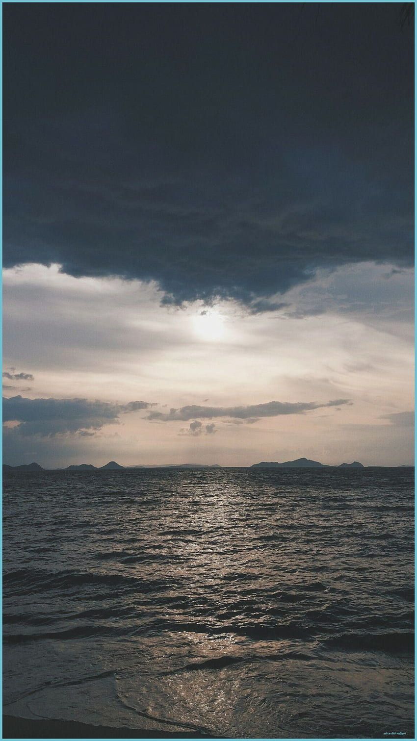 A photo of the ocean with a dark sky - 