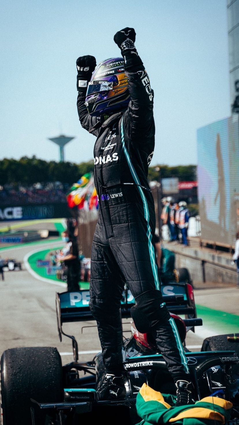 A driver raises his arms in victory - Lewis Hamilton