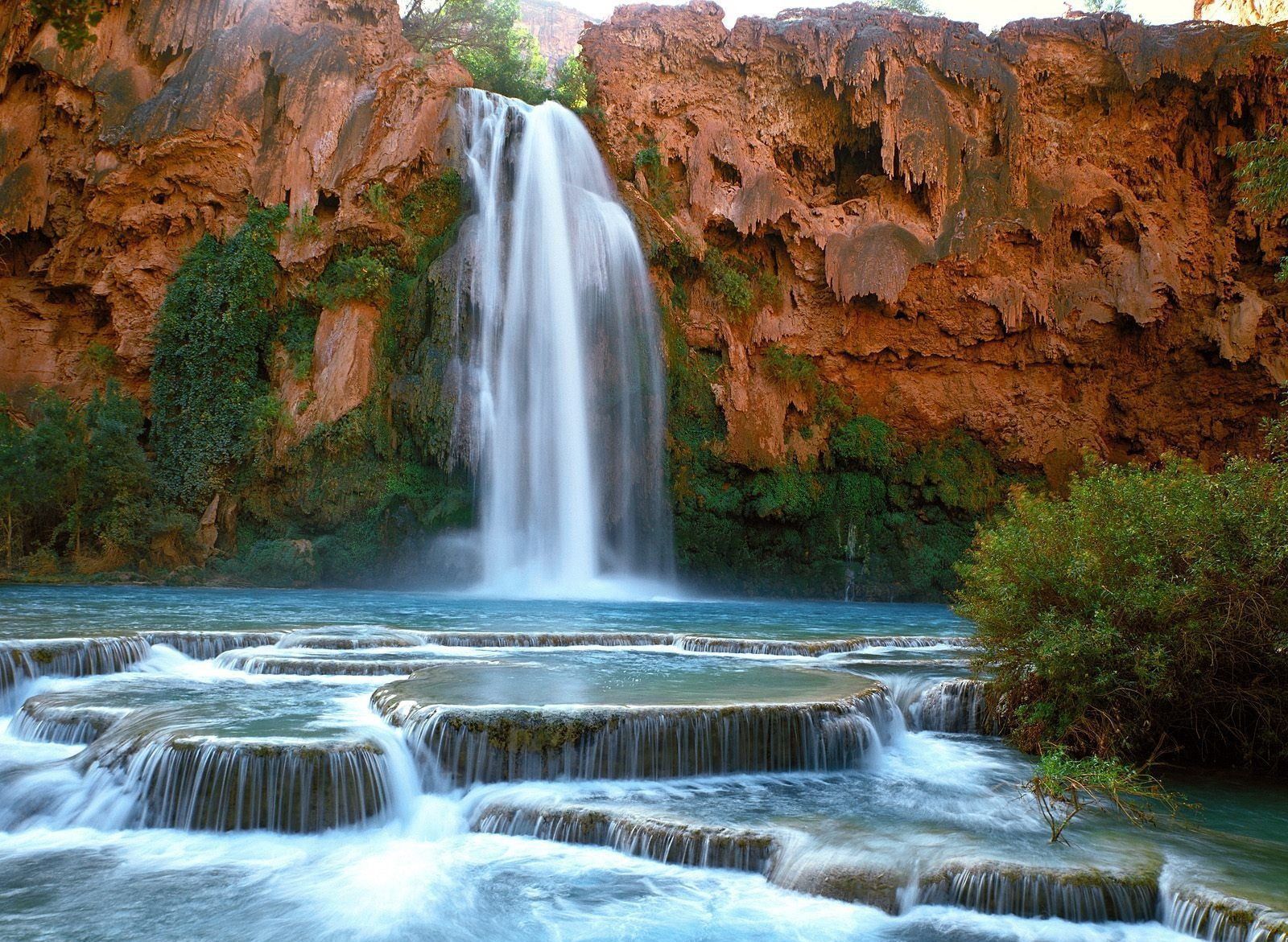 A waterfall in the desert with rocks and trees - Waterfall